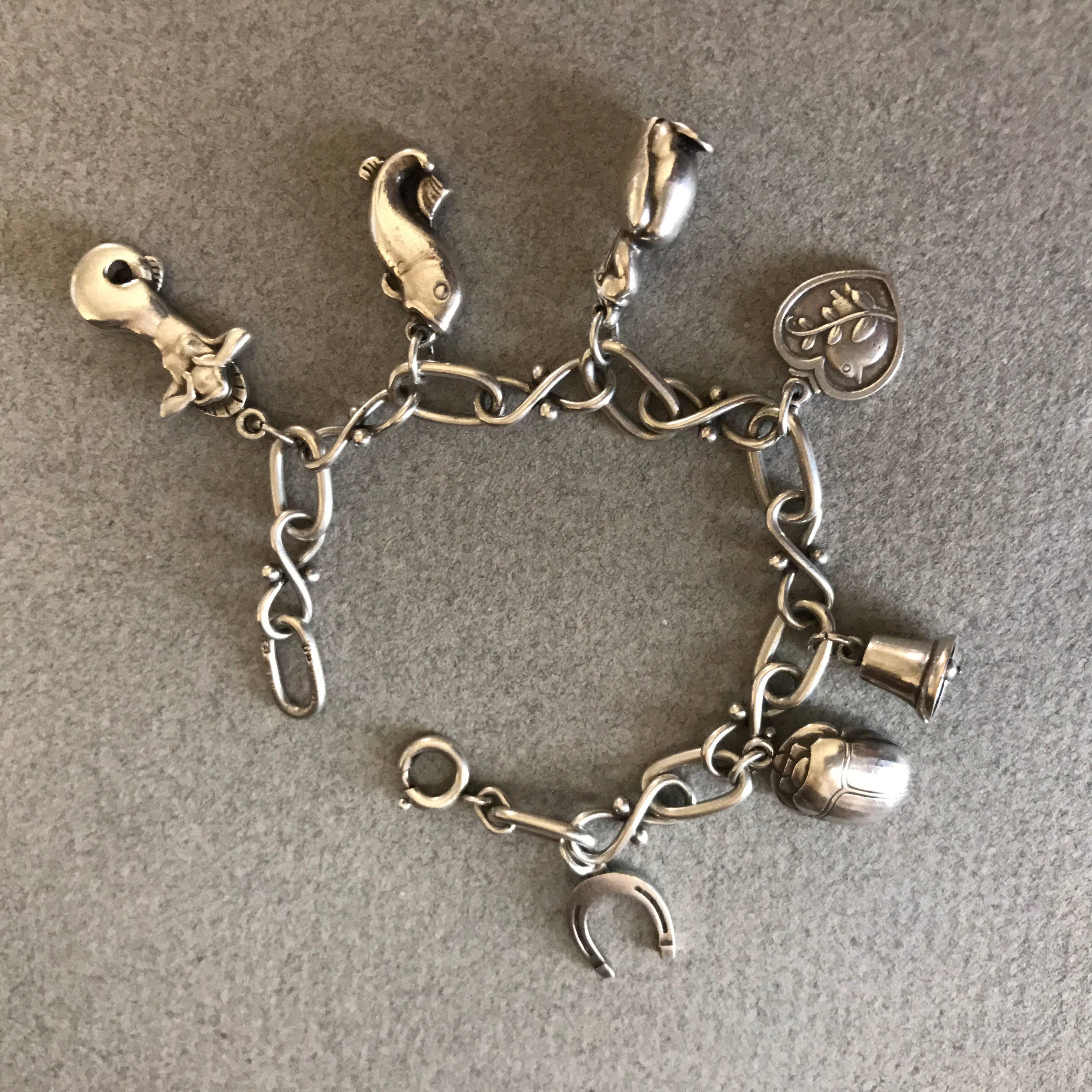 Georg Jensen Sterling Silver Charm Bracelet No. 80.

This is a rare find. Seven unique, solid Georg Jensen sterling silver charms, each stamped with Georg Jensen sterling marks. Comes with original box from the Georg Jensen store on 5th Avenue, New
