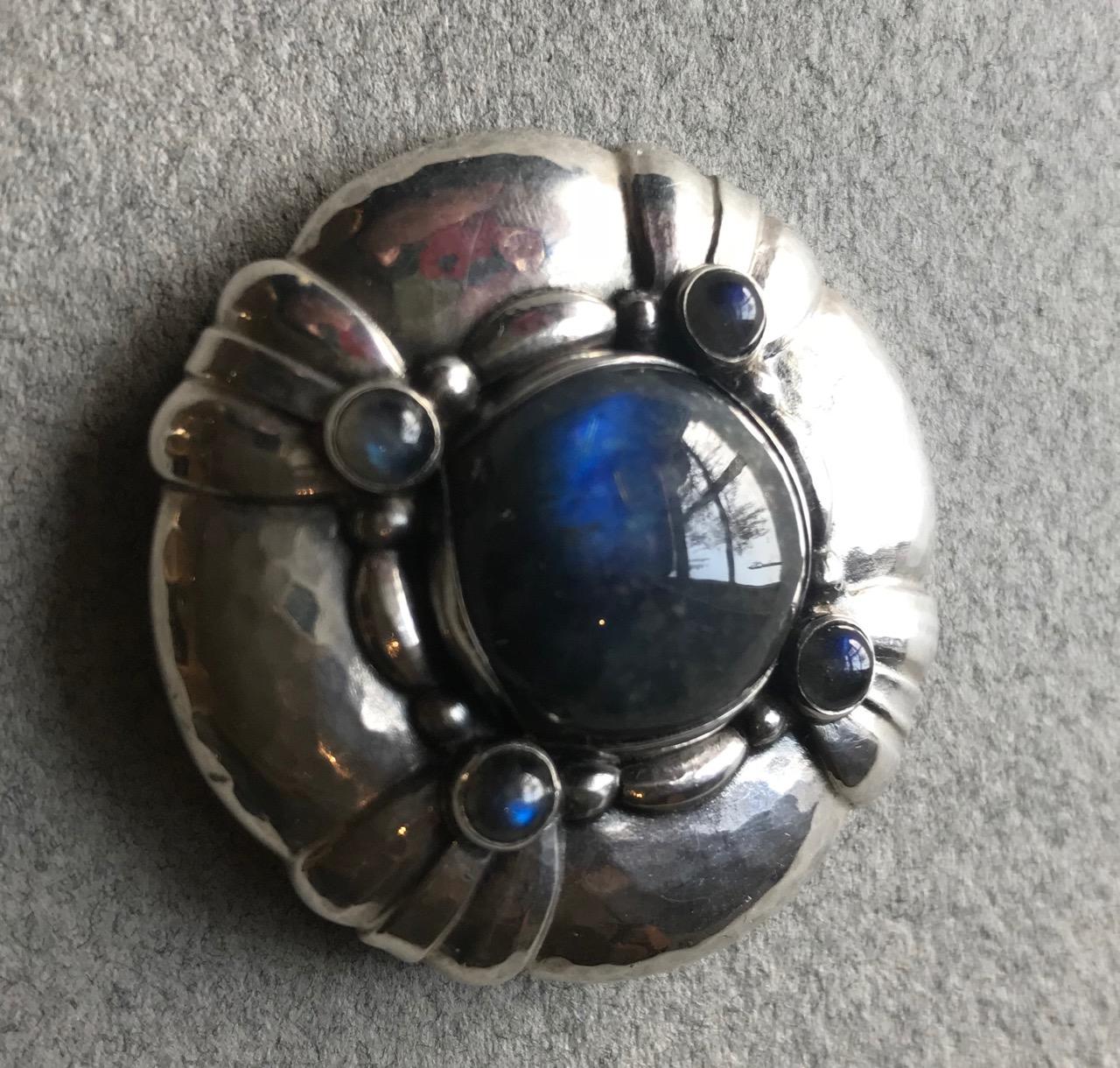 Stunning example of this rare design by Georg Jensen. Excellent patina and visible hand hammering. Labradorite cabochons of bright blue color.  Clasp has been soldered but still functioning and closes securely. 

A similar example can be seen in the