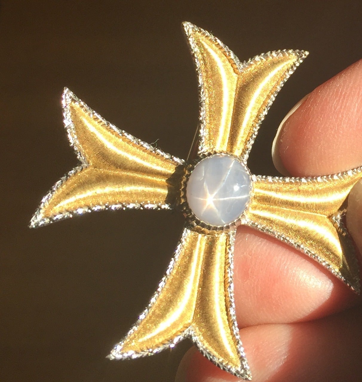 Buccellati Maltese Cross 18K Yellow Gold Brooch With Star Saphire. Very rare.

A brooch of exceptional elegance with a Florentine finish, trimmed in 18K white gold. The center has a natural gray 5 pointed star sapphire, weighing approximately 4.50