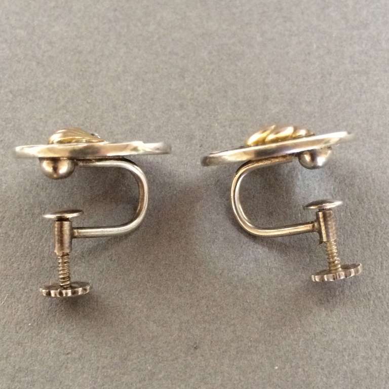 Georg Jensen Nautilus Earrings with 18K Gold Center.  Rare . 

No. 96

Screw backs. Can be converted.

Sterling Silver and 18K