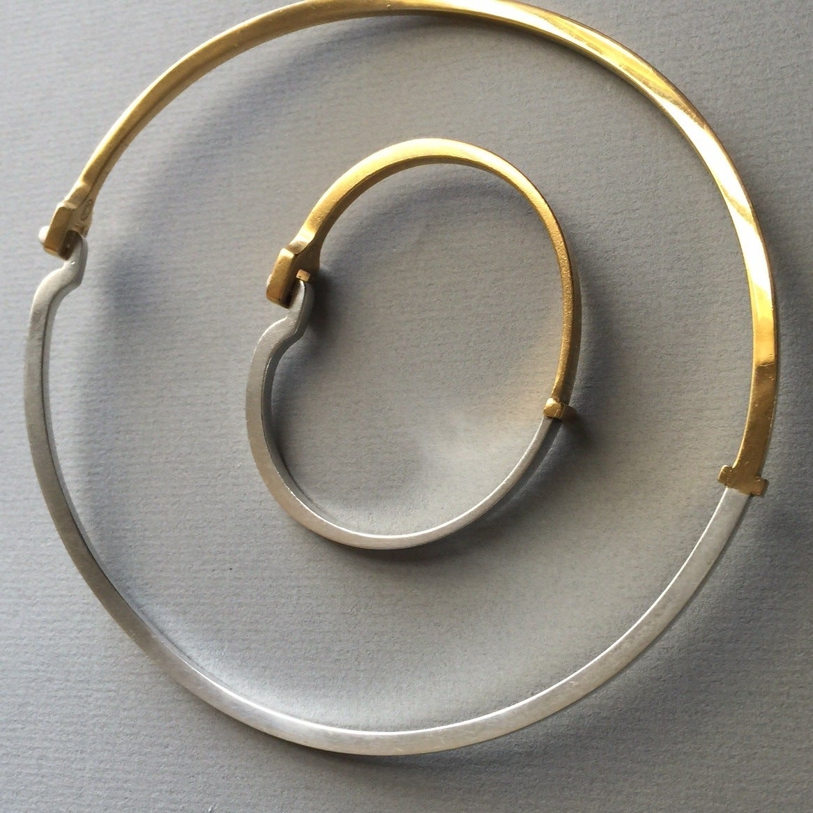 Georg Jensen Sterling Silver & Gold Vermeil Bracelet and Neck Ring Ensemble No. 821B by Andreas Mikkelsen

Modernist sterling silver with gold vermeil neck ring and bracelet ensemble. Simple, timeless design. Both pieces have a unique clasp. 

This
