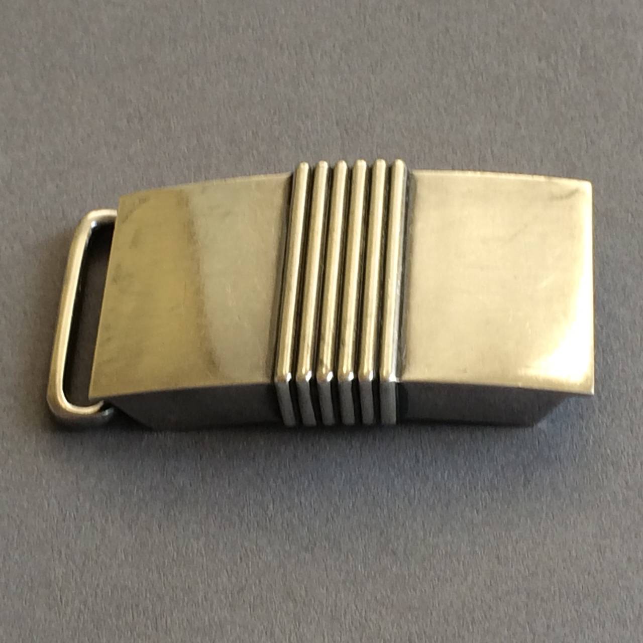 Georg Jensen Belt Buckle No. 76 by Harald Nielsen.

A rare find.  Heavy gauge sterling silver.  Ingenius hinged pressure closure.  Light surface scratchs.

Very good condition. Circa 1940's.

Matching tie bar and cufflinks available.