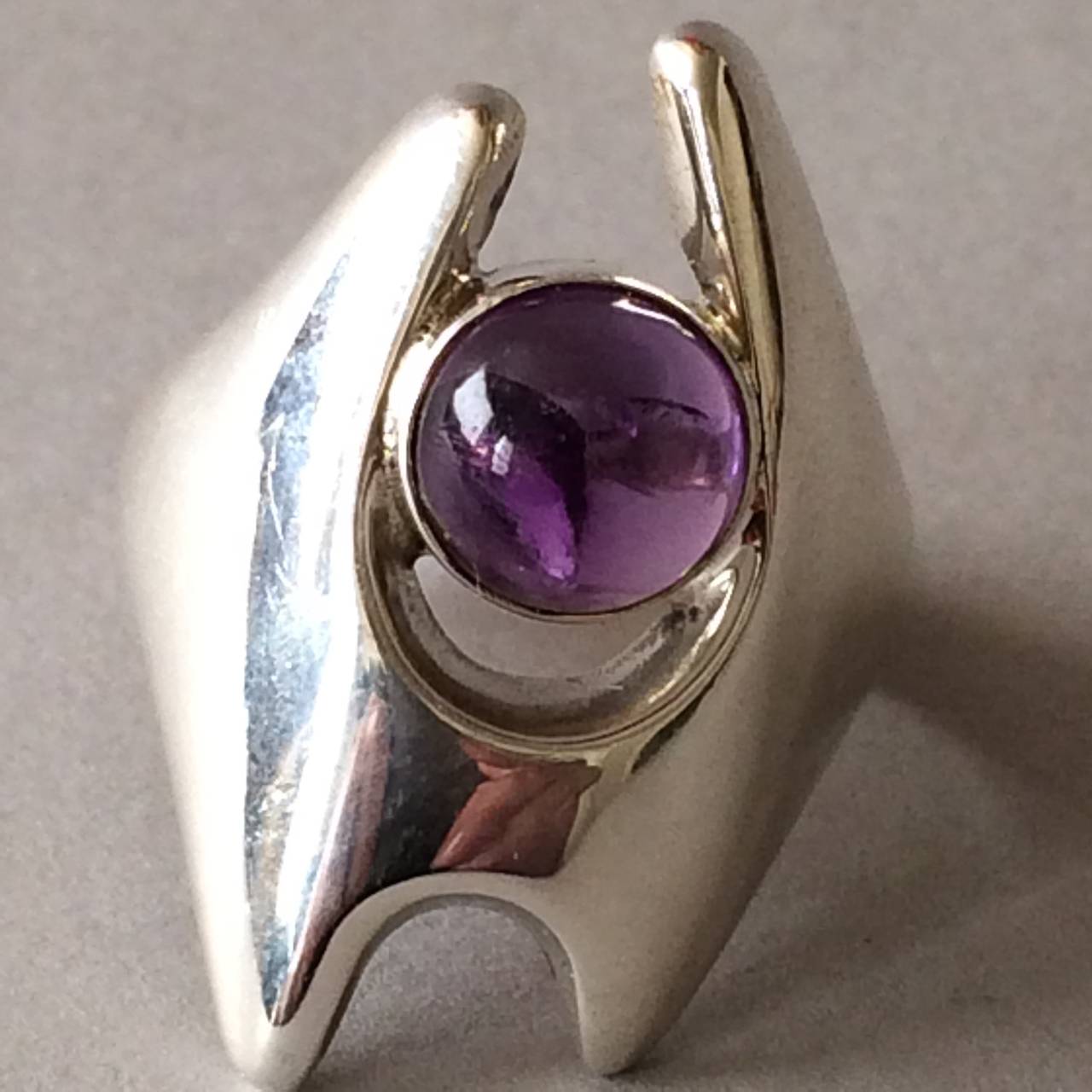 Georg Jensen Sterling Silver Modernist Ring, No. 139 by Henning Koppel with amethyst stone. 925S  

Size 7. 

Sterling Denmark

Henning Koppel (1918 - 1981) was educated as a sculptor and designer at the Royal Danish Academy of Fine Arts in