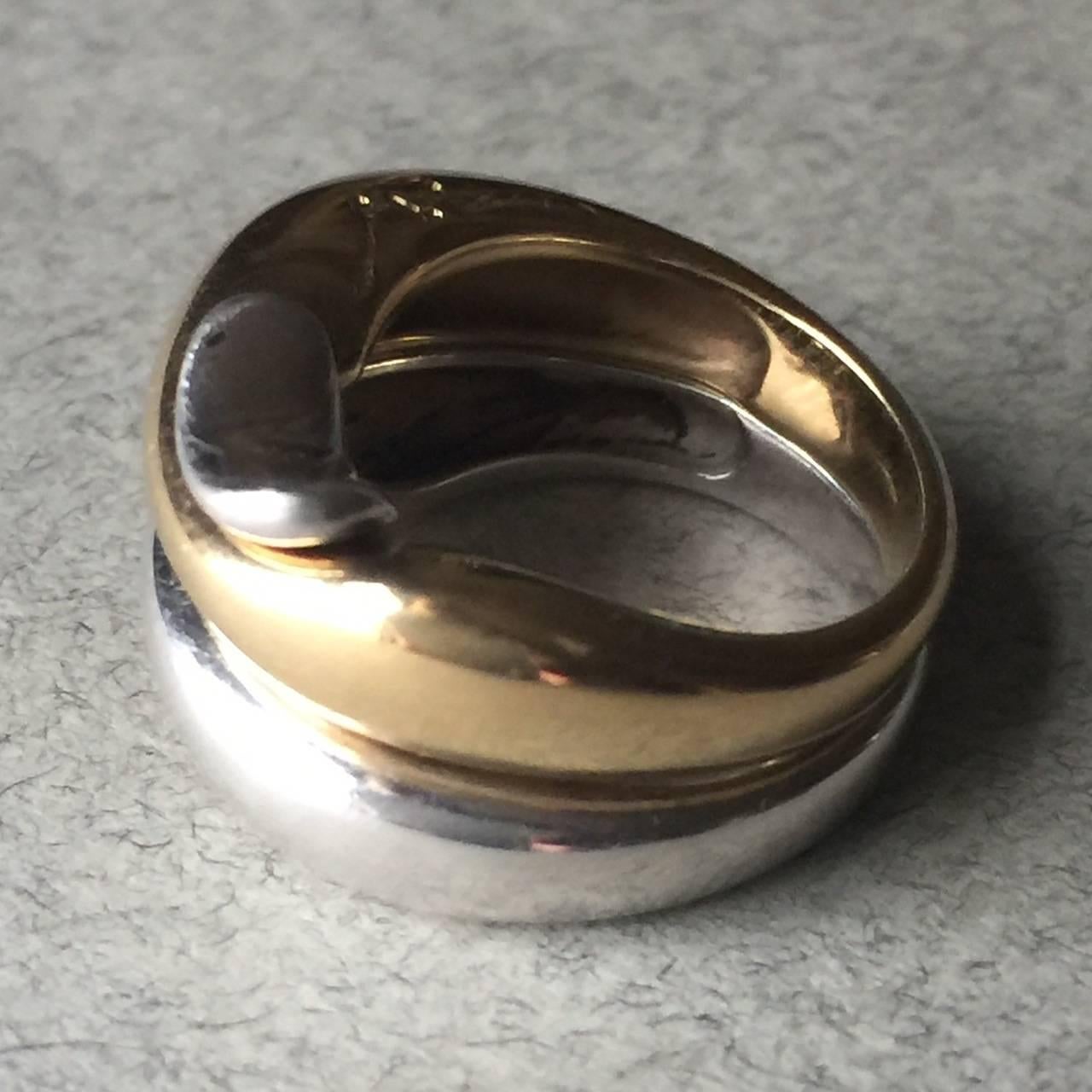 Georg Jensen Sterling Silver and 18KT Gold Puzzle Ring by Minas Spiridis

Rare, bi-color "Puzzle Ring" in excellent condition. Sleek, beautiful, and simple in design.

Size 5. Can be sized for additional cost.

Complimentary gift box and