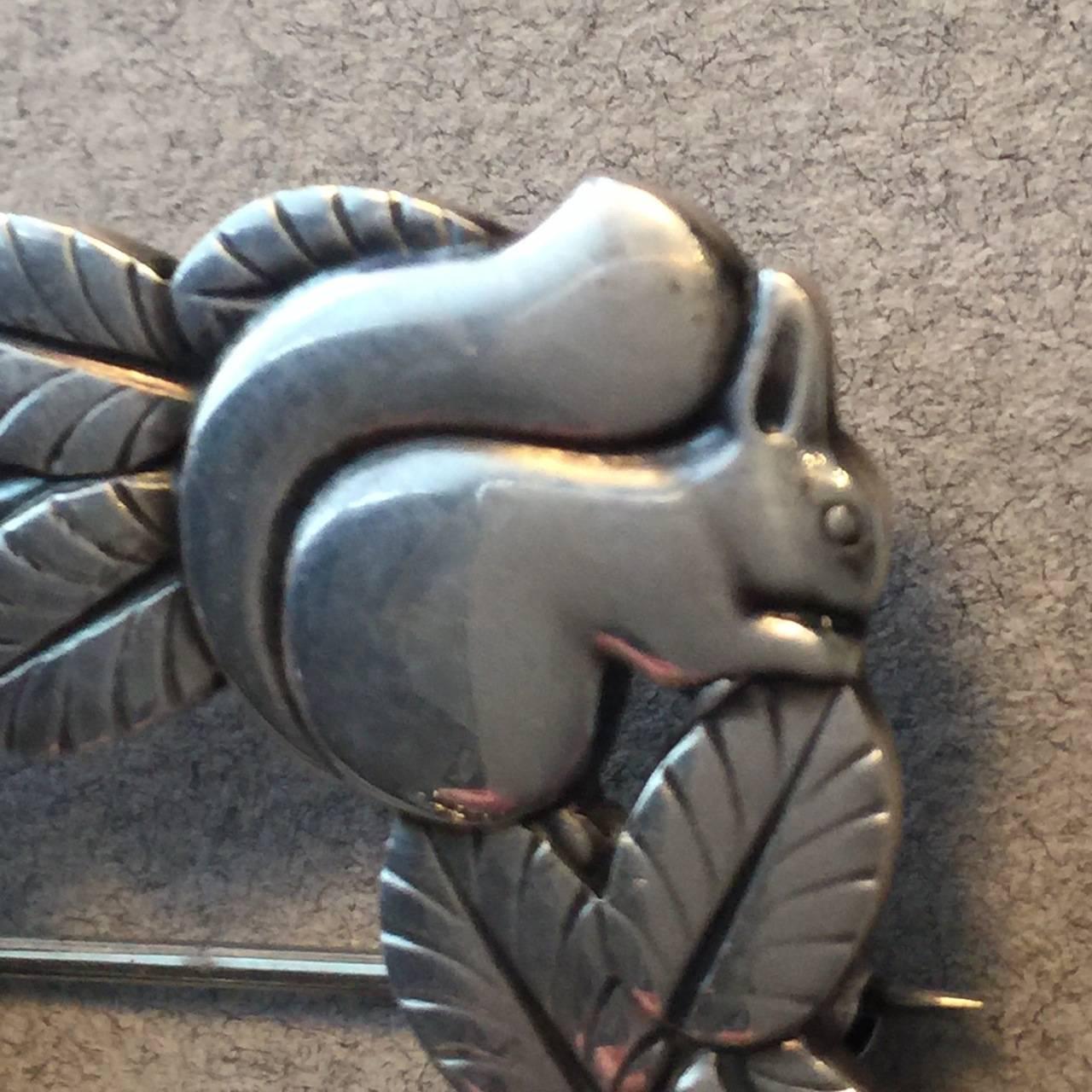 Georg Jensen Sterling Silver Deer and Squirrel Brooch No. 318 by Arno Malinowski

Intricately detailed, open squared brooch that featured a deer resting before a squirrel in foliage. Very well-made with gorgeous patina.

Dimensions: 1.5"