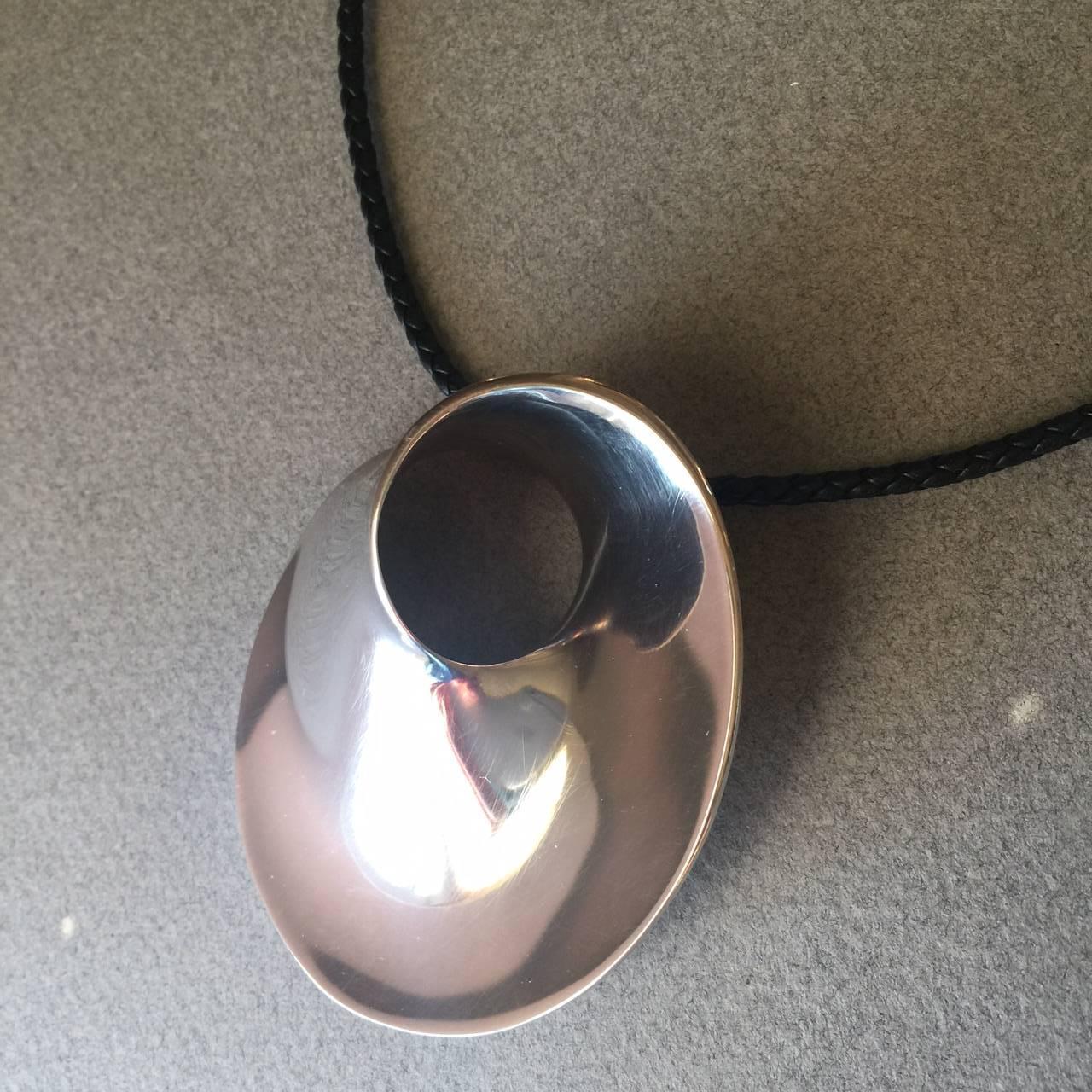 Georg Jensen Sterling Silver "Mobius" Large Pendant-Brooch No. 374 by Vivianna Torun
 
An iconic design that is beautifully sculptural. 

This is a vintage piece from the 1970's that was modified by adding a loop discretely to the back to