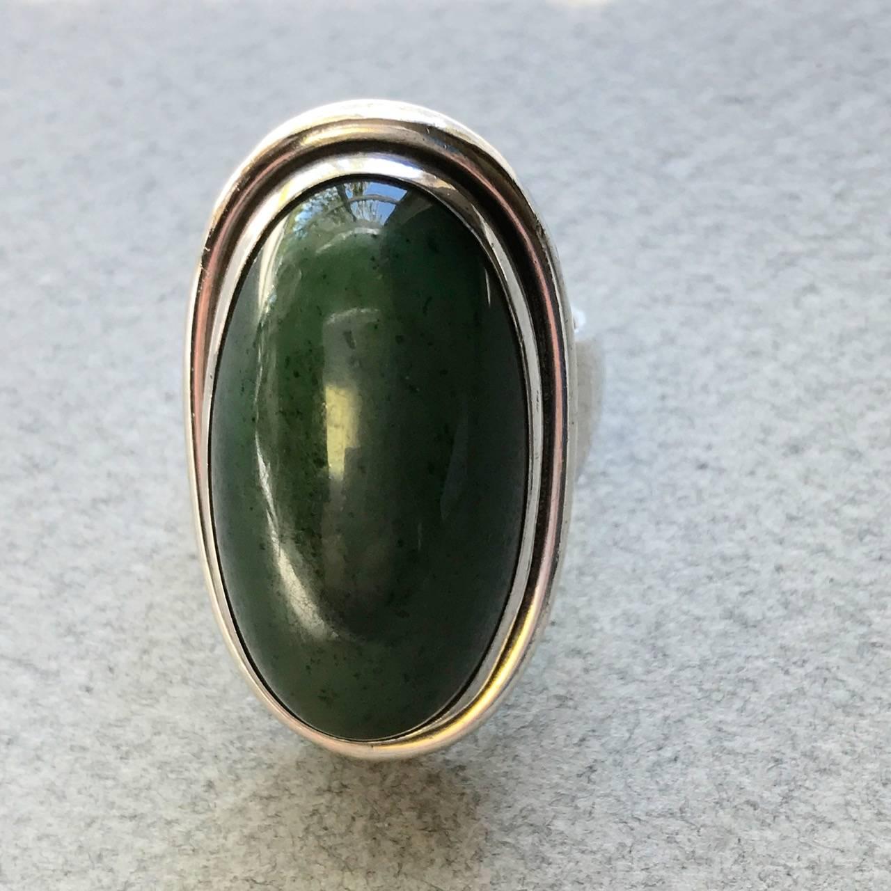 Georg Jensen Sterling Silver Ring No 46E With Jade By Harald Nielsen

This is the largest version of this model. Unusual in that the large piece of mounted jade is speckled. A very bold look and highly sought after Jensen unisex design, this vintage