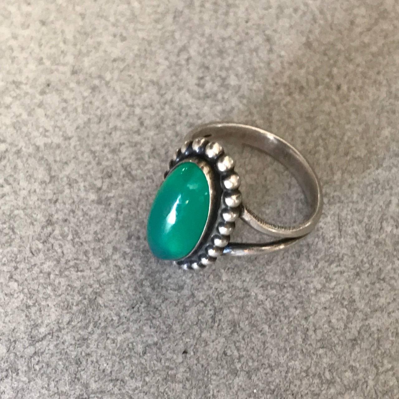 Georg Jensen 830 Silver and Chrysoprase Ring, No. 9

Vivid green cabochon chrysoprase surrounded by oxidized silver beading.

A nice old and early example.

Size 4.5

Complimentary gift box and FREE shipping included.