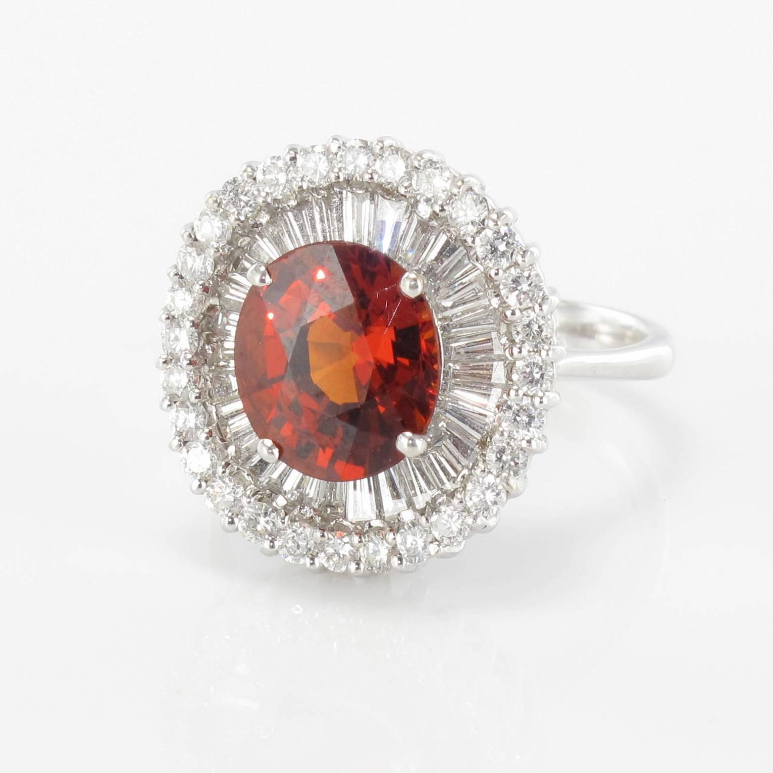 Ring in 18 carat white gold, eagle head hallmark. 

Splendid white gold ring featuring an orange spessartine garnet set with 4 claws in the centre encircled by baguette cut diamonds and brilliant cut diamonds. 

Garnet Weight: 4.05 carat approx