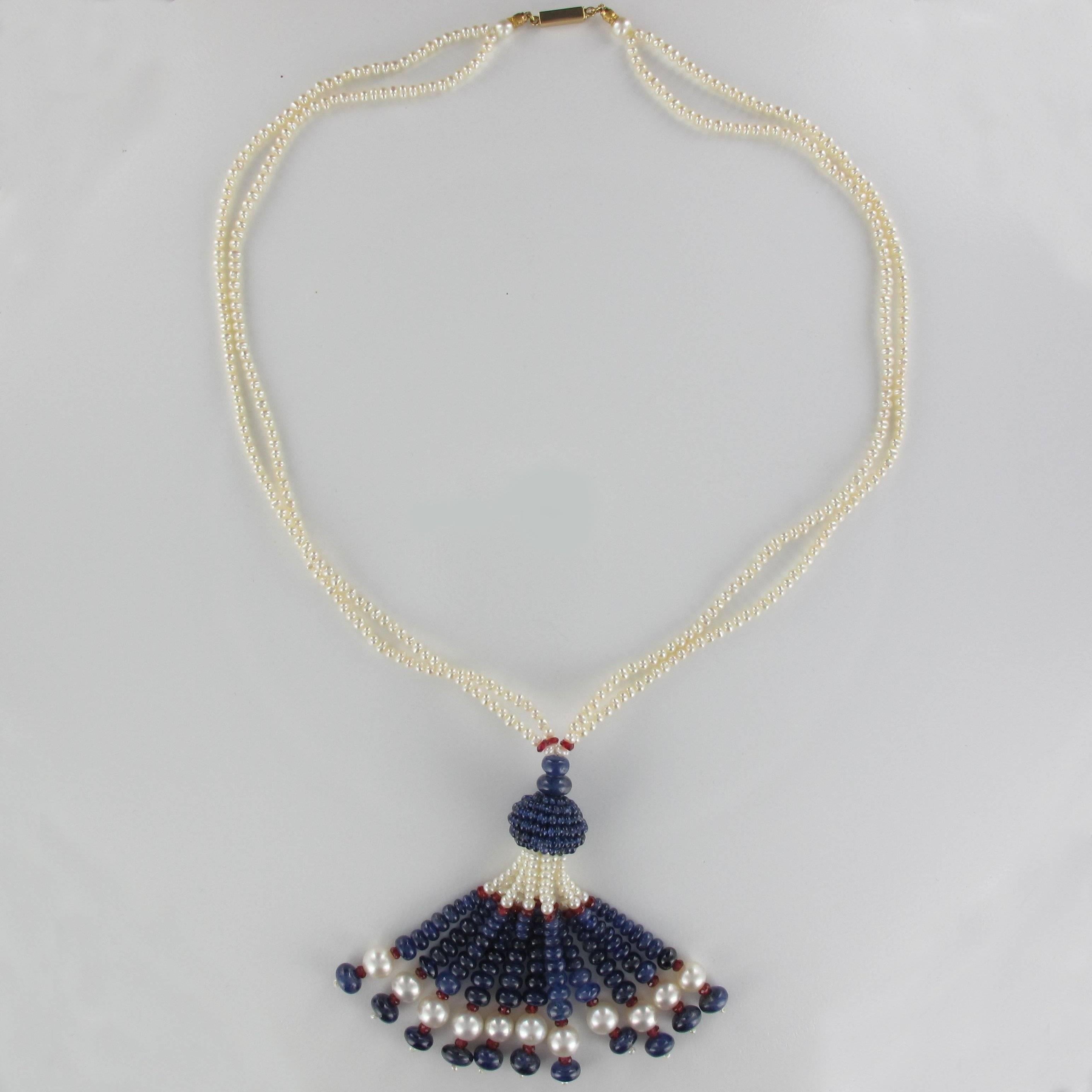 Baume creation - Unique piece.
Pendant in the form of a pompom composed of round and flat sapphire beads, oriental white cultured pearls and flat tourmaline beads. It is secured at each side by cultured white oriental pearls. The clasp is of 18