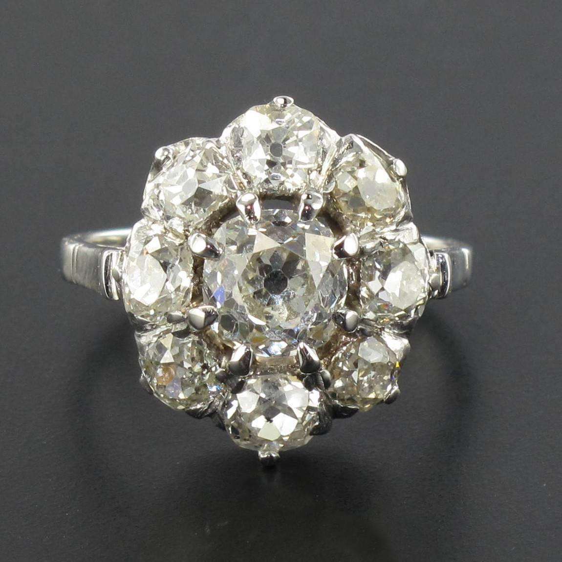 Platinum ring.

This delightful antique Daisy style ring has a claw set oval antique diamond surrounded by 8 antique cushion cut and brilliant cut diamonds. 

Weight of the center diamond : approximately 1.20 carat 
Total weight of other