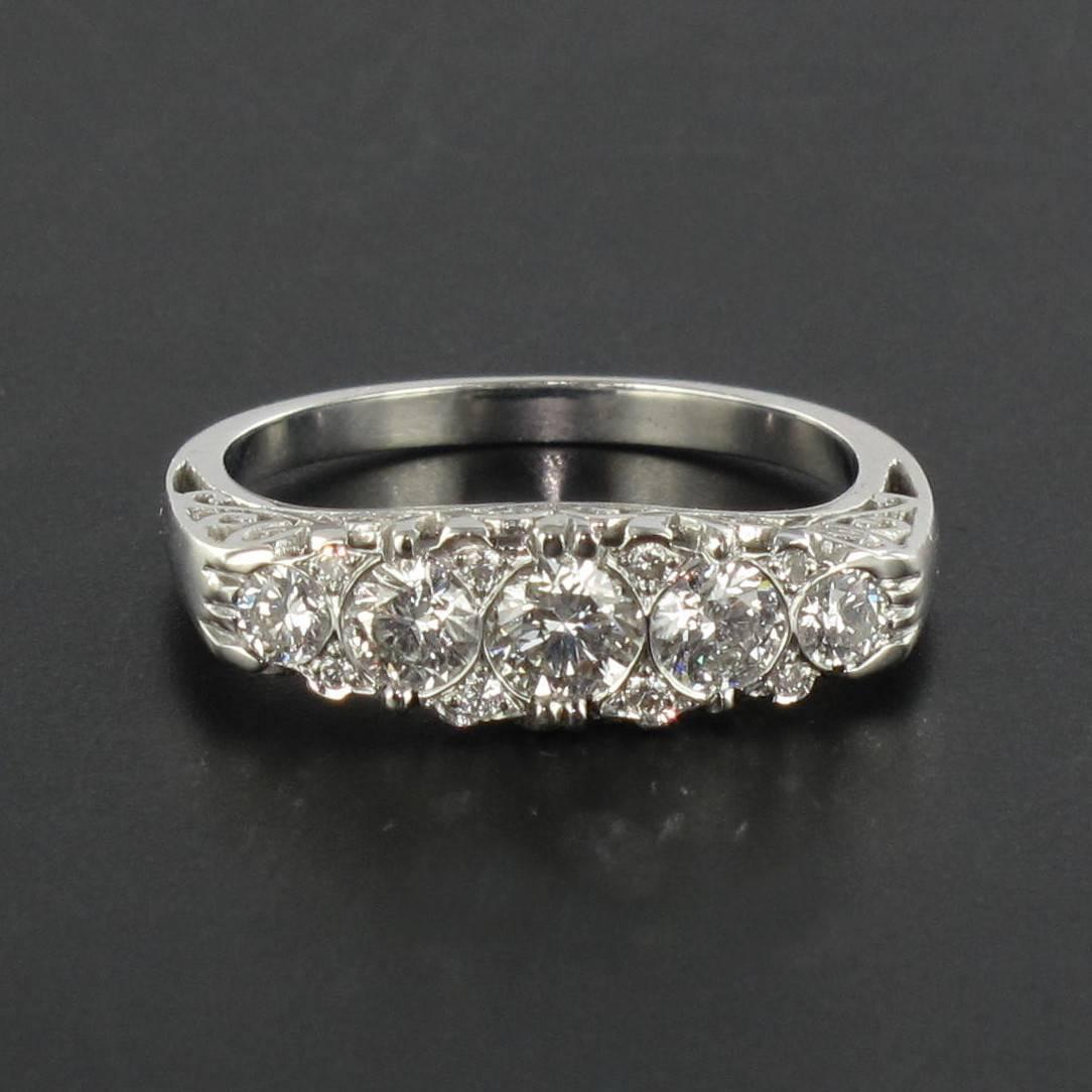 Ring in 18 carat white gold, eagle head hallmark. 
This stunning and highly feminine diamond ring features 5 brilliant cut diamonds set in a row interspersed by a further 8 smaller diamonds. The curved profile is in arabesque openwork. 
Total