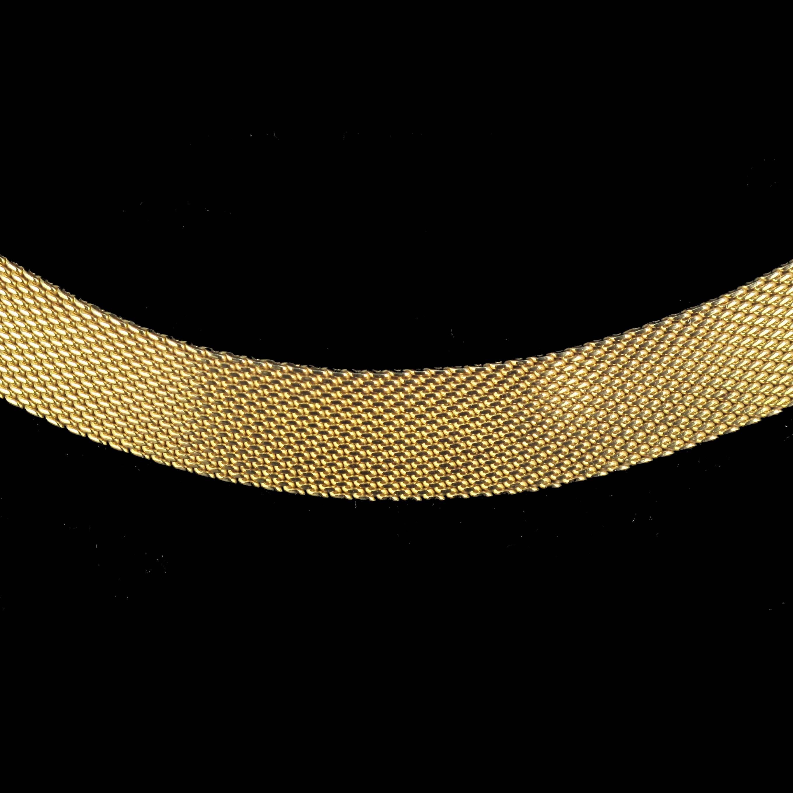 Necklace in 18 carat yellow gold.
This splendid vintage necklace could be described as perfection incarnate. It sits on the neckline gracefully and elegantly. This flat antique necklace is composed of a tight mesh of golden strands. The clasp is a