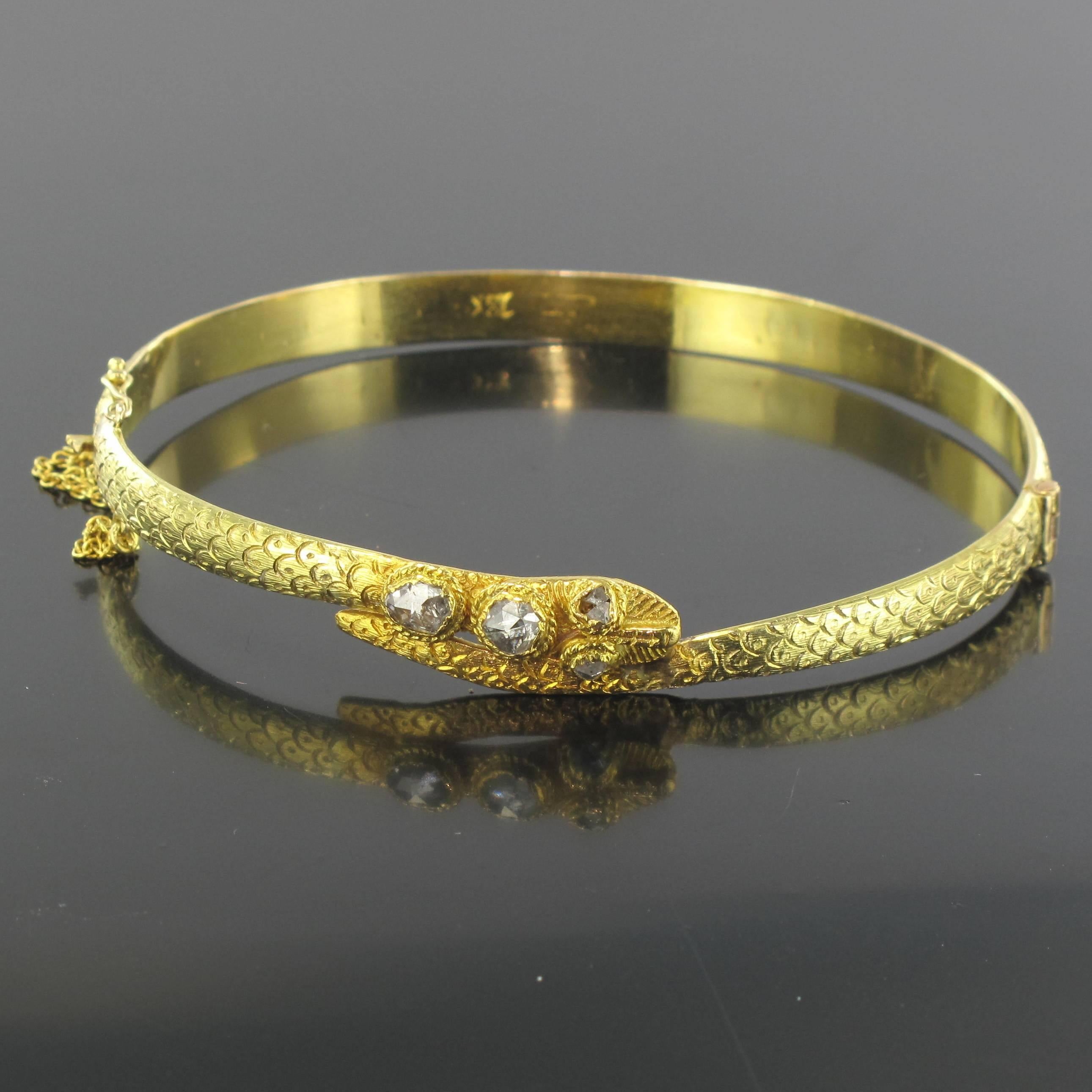 18 carat Yellow gold bracelet. 

This ravishing antique oval bangle bracelet is in the form of a snake curled around the wrist. The scales are delicately engraved on the entire top surface. The head is set with 4 rose cut diamonds; those of the