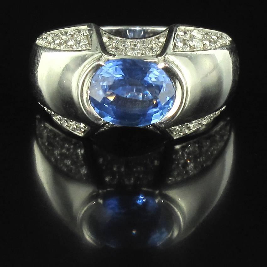 Ring in 18 carat white gold, eagle head hallmark. 

This ring has a double half moon design featuring a central oval blue sapphire with pave diamonds on each side around the edges. 

Sapphire weight: 2.28 carats approximately, 
Total diamond