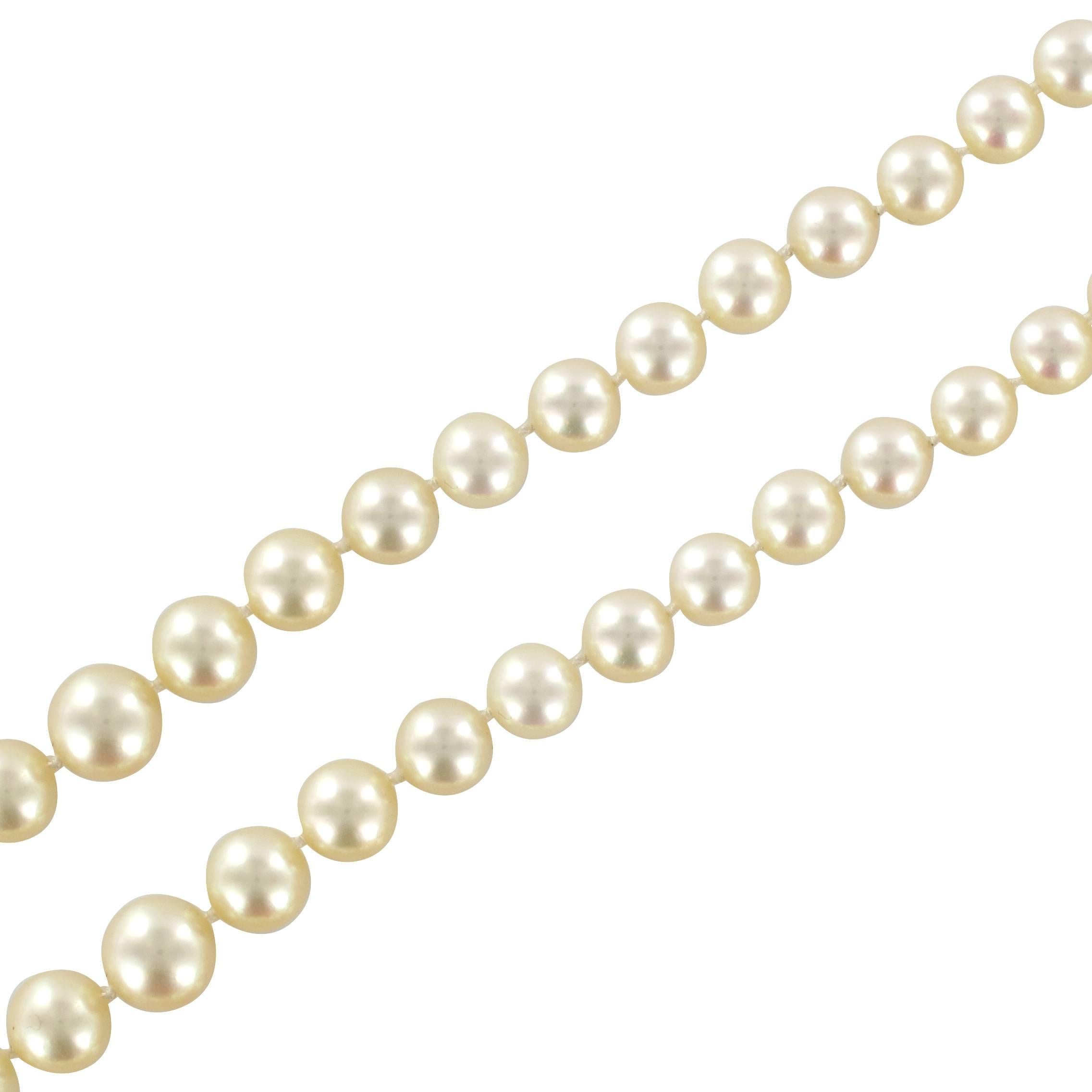 Antique pearl necklace composed of two strands of Japanese cultured pearls. The double row of pearls is fastened by a round double clip clasp of 18 carat white gold, eagle head hallmark. This is set with a round cultured pearl surrounded by 5 round