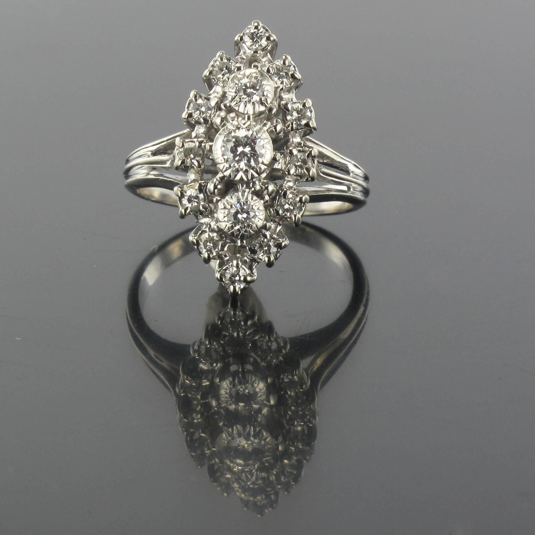 Ring in Platinium and 18 carat white gold, eagle and dog heads hallmarks. 

This antique marquise ring is bezel set with 3 modern brilliant cut diamonds in a star design. The one in the centre is larger. These diamonds are surrounded with 12 other