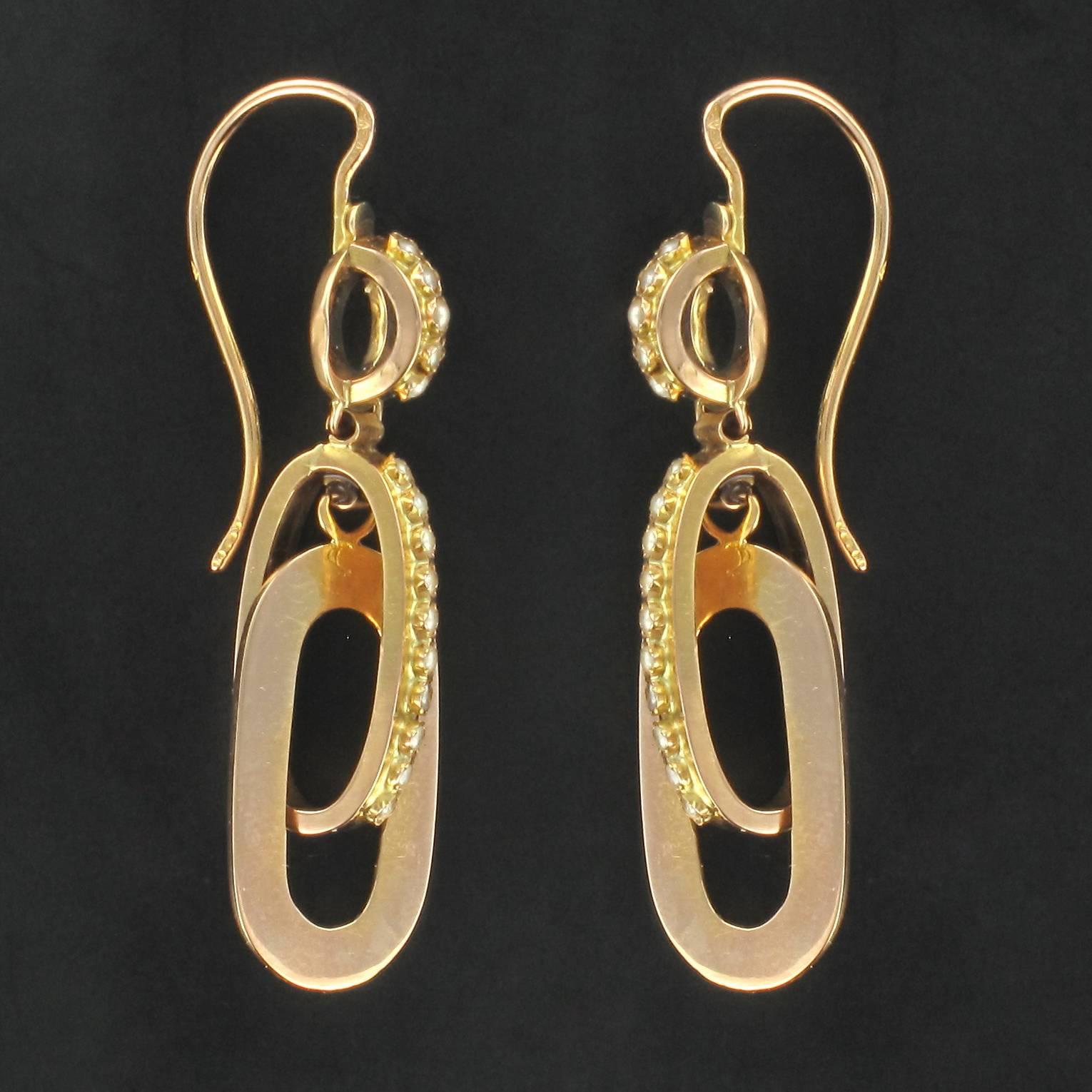Earrings in 18 carat rose gold, horse head hallmark. 

Each dangle earring is composed of a gold loop set with a column of small half fine pearls from which 2 linked oval gold hoops are suspended. One of these is set with small half fine pearls,