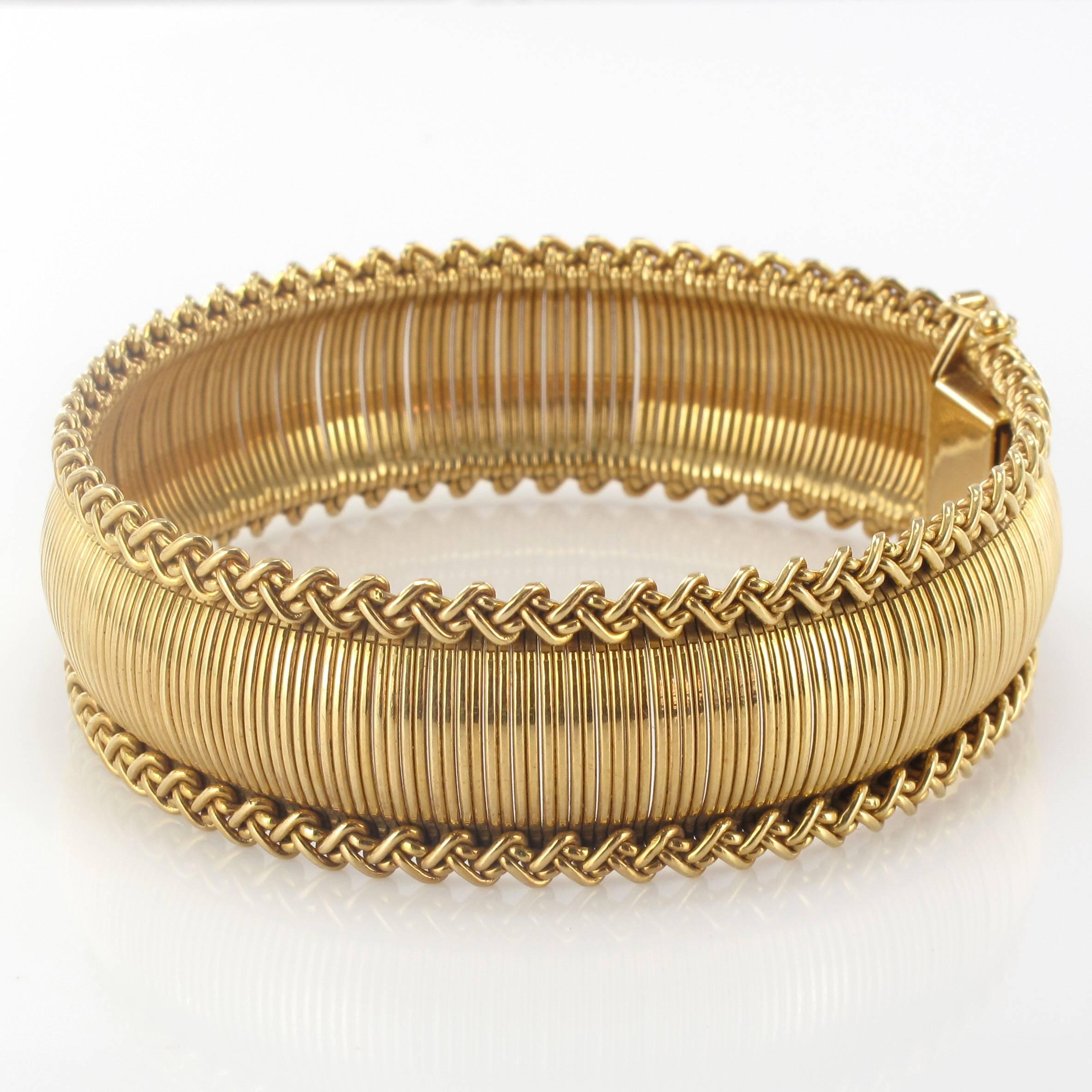 Bracelet in 18 carat yellow gold, rhinoceros hallmark. 
The mesh resembles golden baize edged with gold braid. The clasp is a ratchet with a safety ‘8’. 
Length: 19 cm, width: 2 cm.
Total weight : 50.4 g approximately.
Authentic vintage bracelet –
