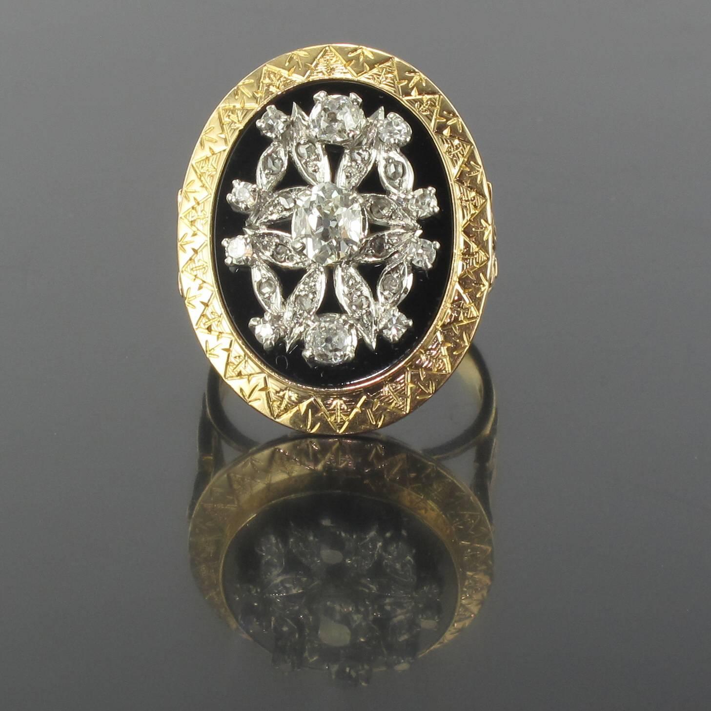 Ring in platinium and 18 carat yellow gold, dog and eagle heads hallmarks. 
This magnificent antique ring is composed of a delicately chiselled oval mount bezel set with an onyx disc displaying a raised platinum design set with small rose cut