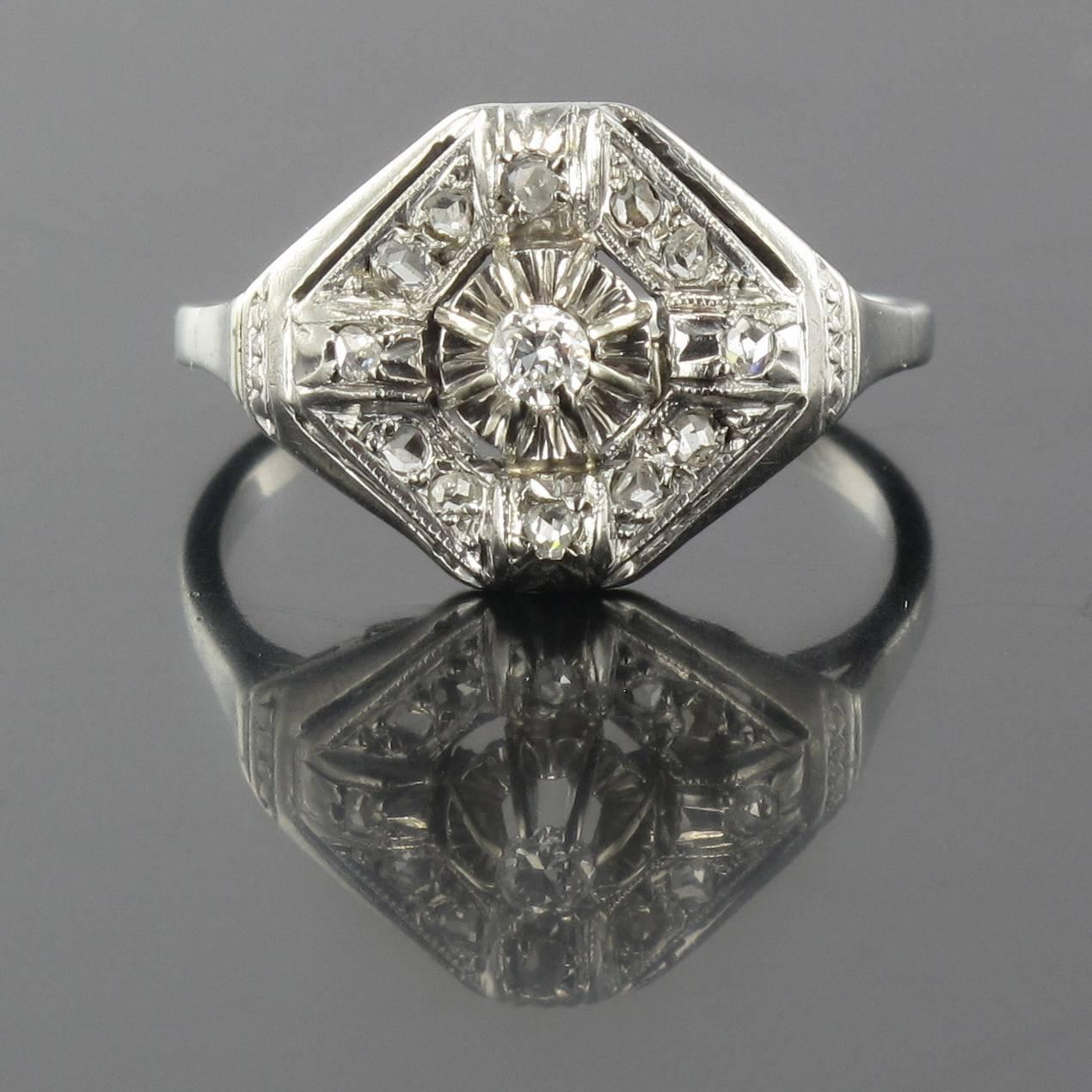 Ring in platinium and 18 carat white gold, dog and eagle heads hallmarks. 

This exquisite antique ring is claw set with a medium sized brilliant cut round diamond in an openwork lozenge shaped design set with small rose cut diamonds. The mount of