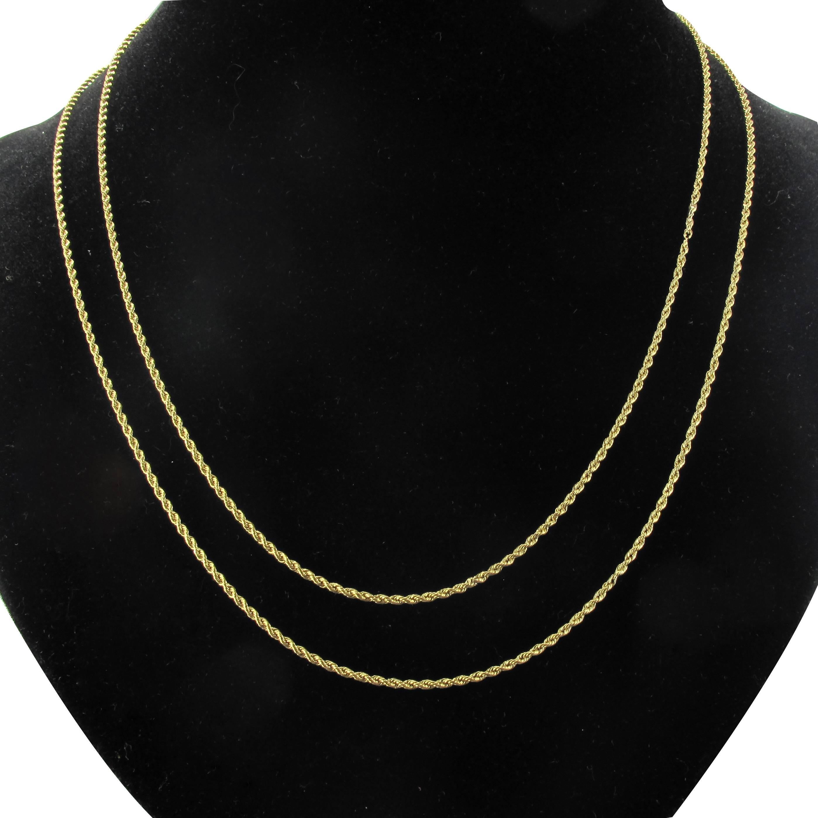 Long necklace in 18 karat yellow gold, eagle head hallmark. 
This matinee chain necklace is composed of twisted gold double links. The chains are connected by an engraved golden bead decorated with green gold leaves. This is attached to a screw hook