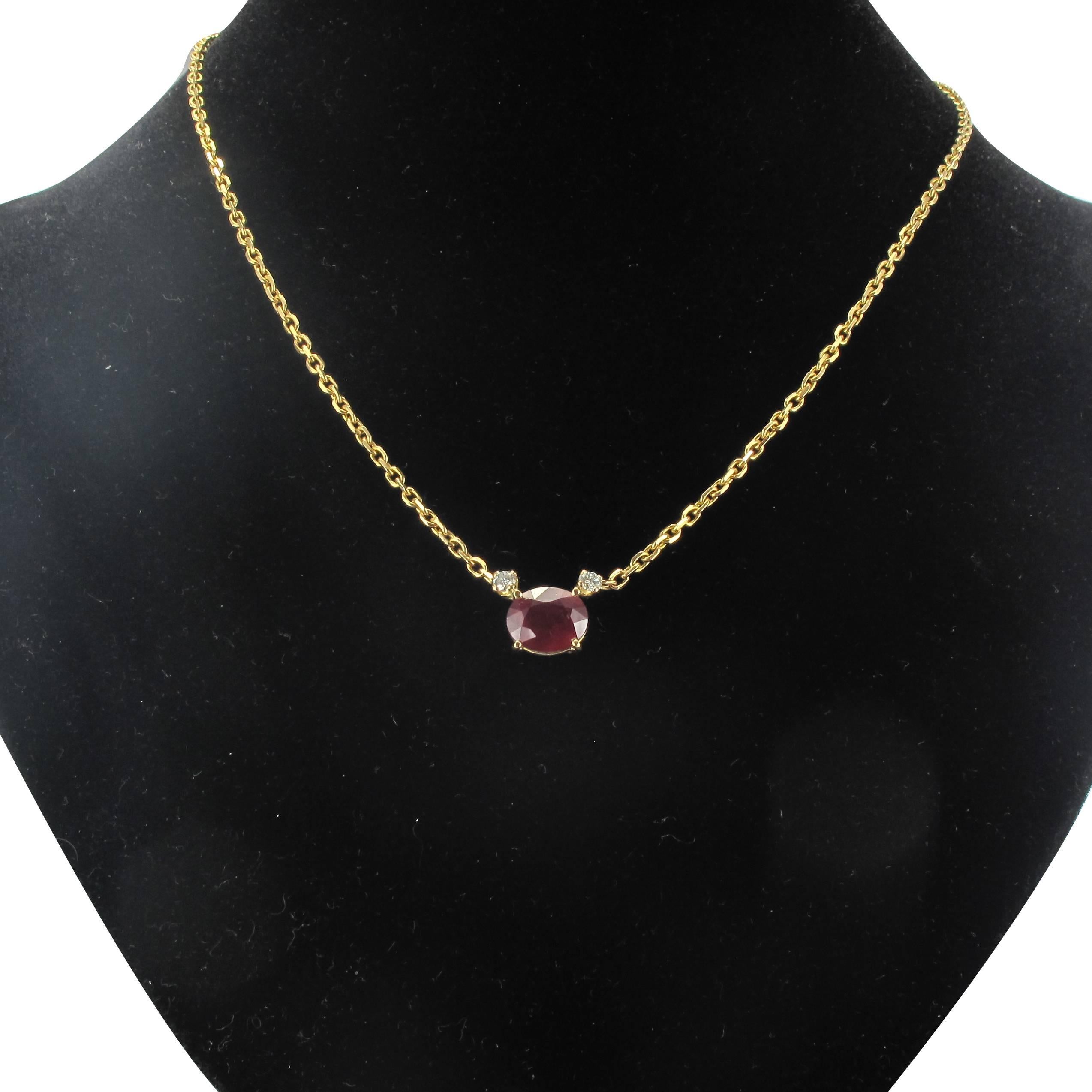 Necklace in 18 carat yellow gold, eagle head hallmark. 

This magnificent golden necklace is composed of a brushed link golden chain with a frontal motif featuring a claw set oval ruby with a modern brilliant cut diamond at each side. 

The