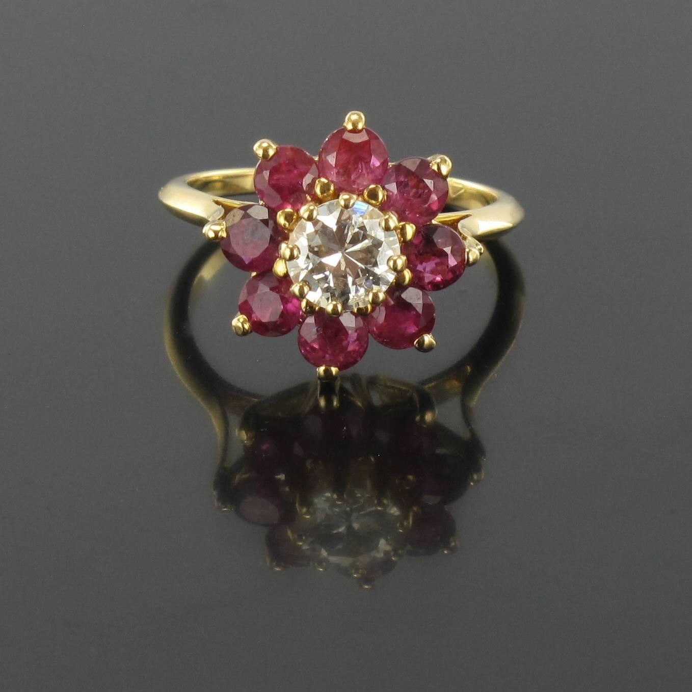 Ring in 18 carat yellow gold, eagle head hallmark. 
Claw set with a modern brillant cut diamond surrounded by 8 rond cut rubies
Diamond Weight: 0.45 carat about - Quality estimated diamond H / V
Rubies total weight : about 1.6 carat
Head diameter: