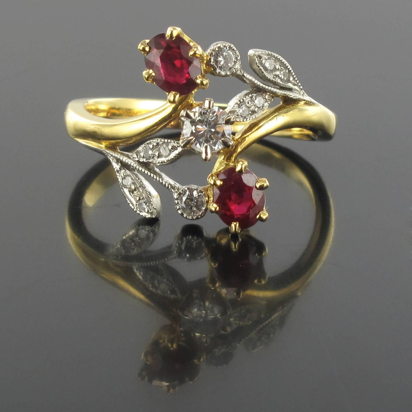 Ring in 18 carat yellow gold, and platinium, dog and eagle heads hallmarks. 

This ring is claw set with a brilliant cut diamond with oval rubies above and below surrounded by a floral décor entirely set with diamonds. 

Weight of ruby: 0.59