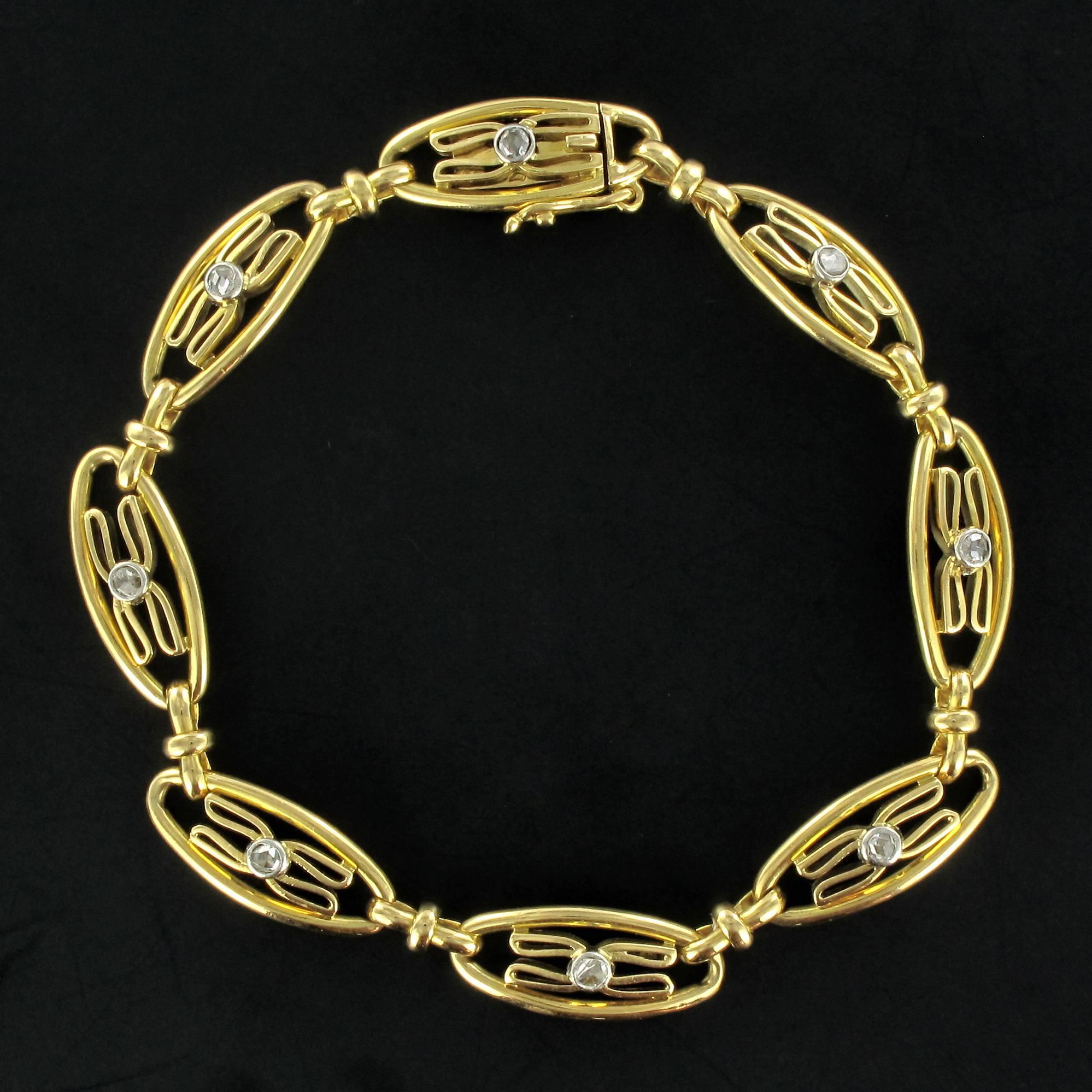 Bracelet in 18 carat yellow gold, eagle head and rhinoceros hallmarks. 

This bracelet is composed of 8 openwork shuttle shaped links each decorated with a bow featuring a central rose cut diamond. They are linked by small gold ties. The ratchet