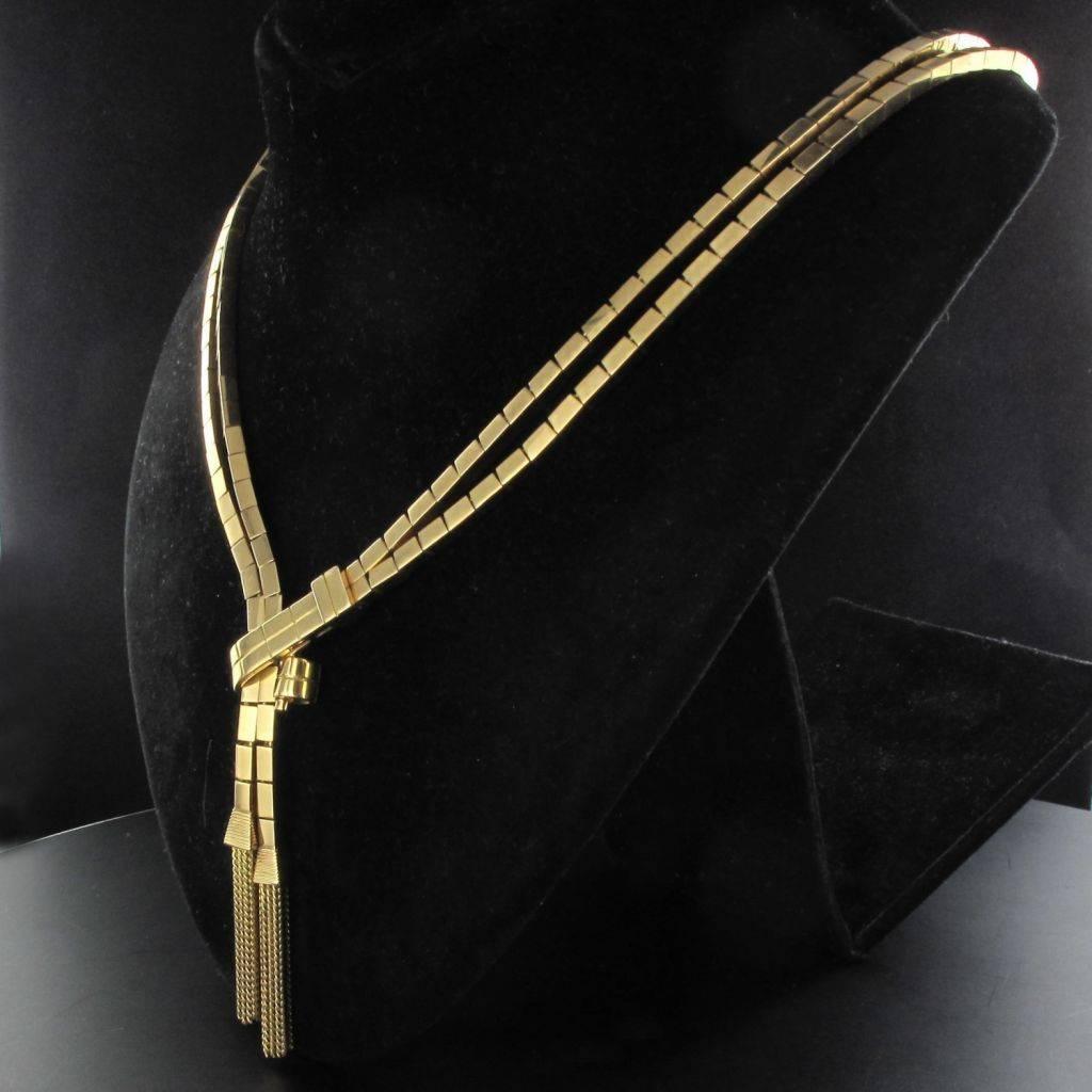 Necklace in 18 carat yellow gold. 

This tank necklace is composed of 2 rows of articulated rectangular links. One side is attached to the other by 2 gold fringed tassels. This necklace has a clip clasp featuring a safety 8. 

Total weight: 71.6