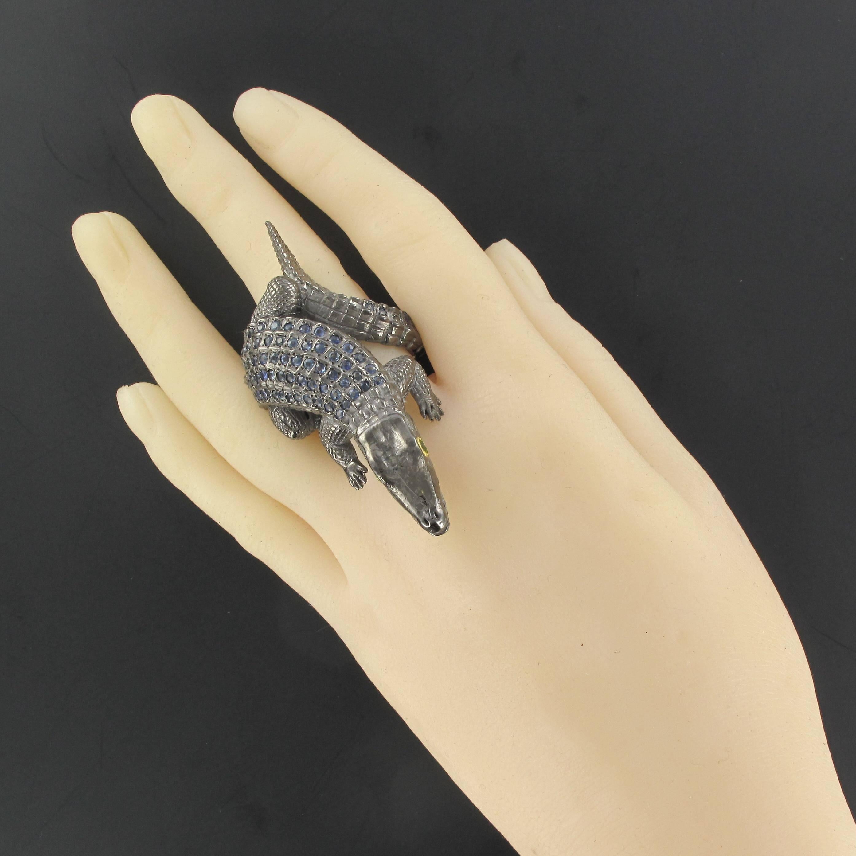 Blackened silver ring.
This fantastic animal themed ring features a crocodile that is entwined around your finger. In an attack position, with its mouth open this silver reptile has sapphire scales and is highly realistic. 
Sapphires weight: 2.05