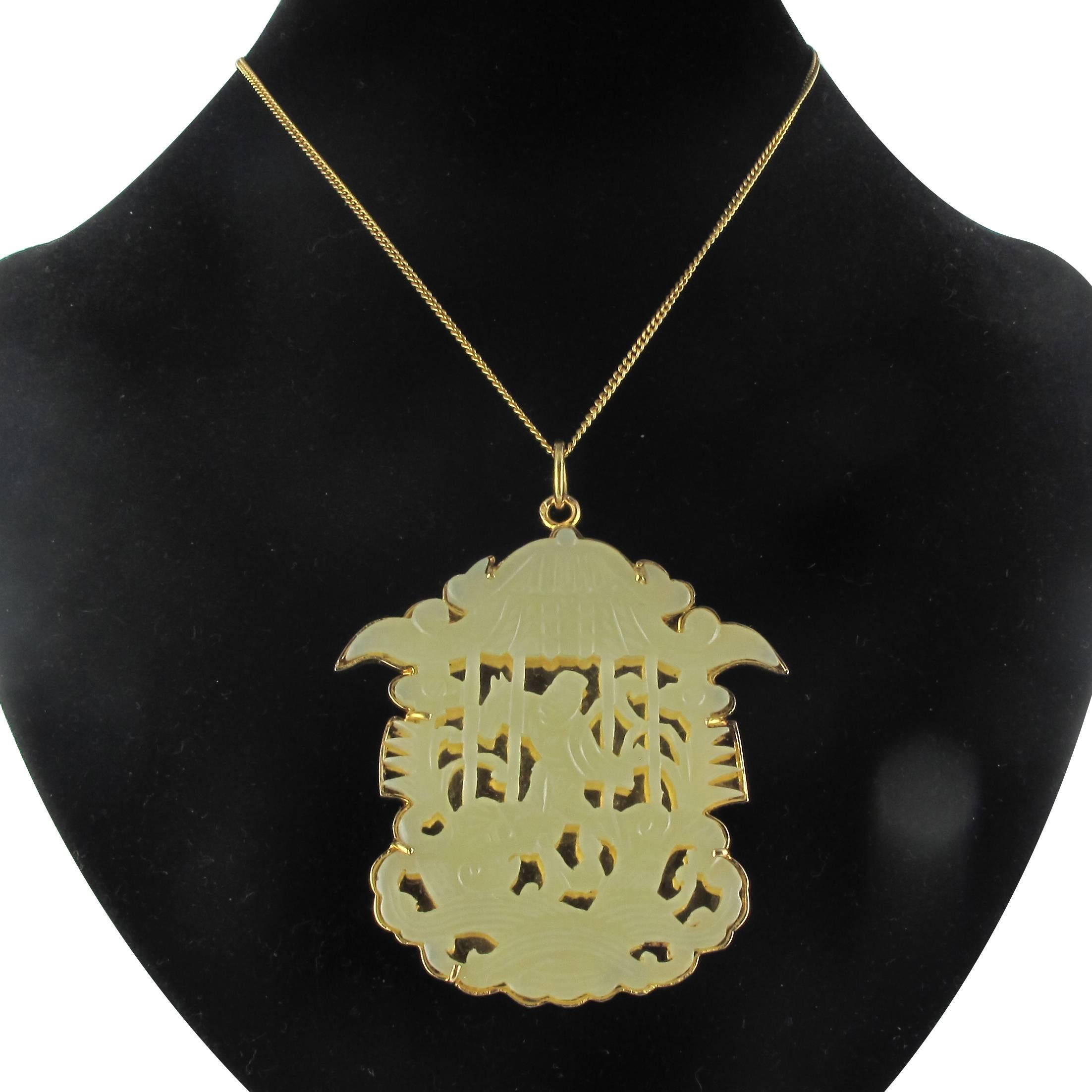 Pendant in 18 carat yellow gold. 

This rare and sizeable antique pendant features a claw set openwork pale green jade gemstone on a smooth golden back. The engraved design features a pagoda with a person. 

Total height: 6.8 cm, width at