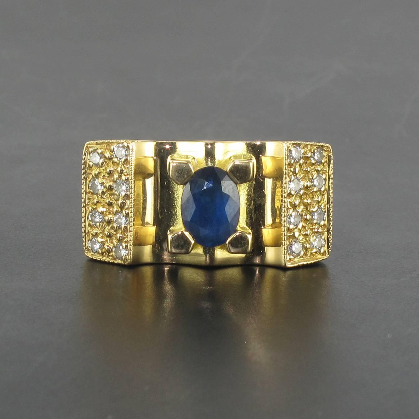 Ring in 18 carat yellow gold, eagle head hallmark. 

This sapphire ring is reminiscent of the tank rings of the 1940s. In the form of a bridge the central faceted oval blue sapphire is held by 4 large claws and set at each side with 8 brilliant