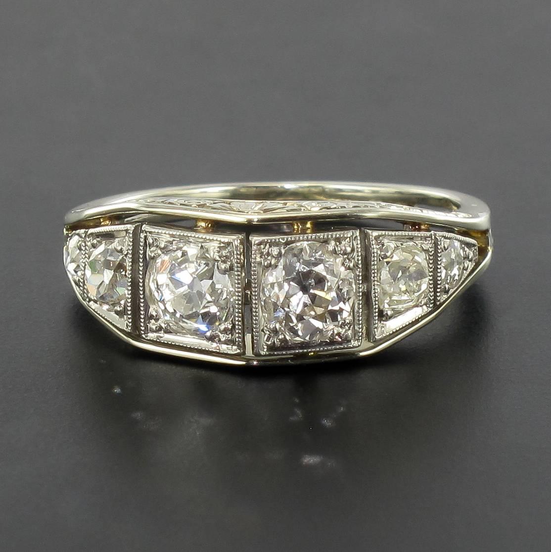 Ring in platinium and 18 carat white gold, dog and eagle heads hallmarks.

This splendid antique ring features a line of 5 antique brilliant cut diamonds surrounded by a wavy motif also set with 10 antique brilliant cut diamonds. The ring bed is