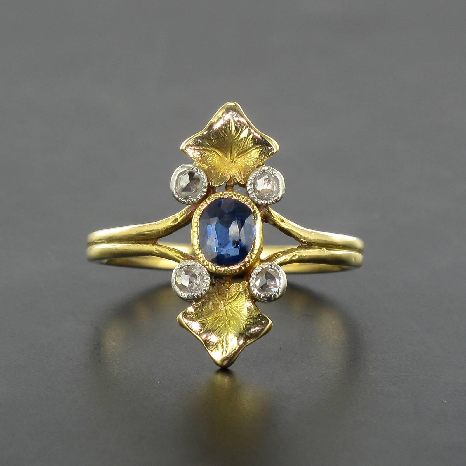 Ring in 18 carat yellow gold, eagle head hallmark. 

This gorgeous antique ring is bezel set with an oval sapphire with a beaded surround with 4 brilliant cut diamonds bezel set at its cardinal points also in beaded settings. Two finely engraved