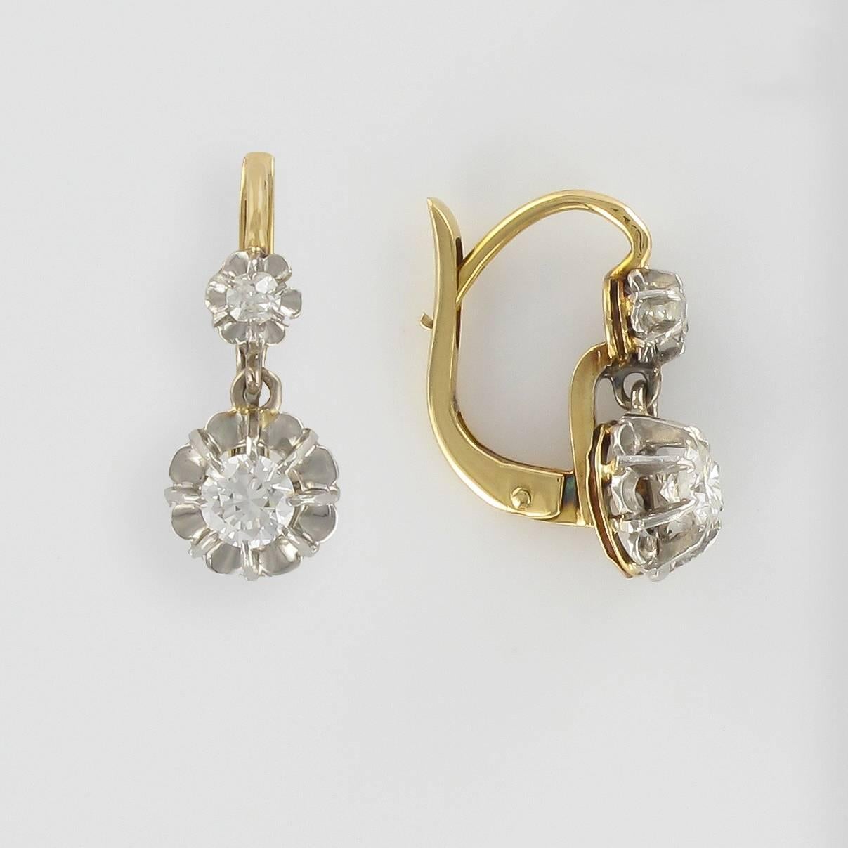 For pierced ears.
Pairs of earrings in 18 carat white and yellow gold, eagle head hallmark. 

Each diamond earring features a claw set cushion cut diamond from which is suspended a much larger cushion cut diamond in an illusional setting. The clasp