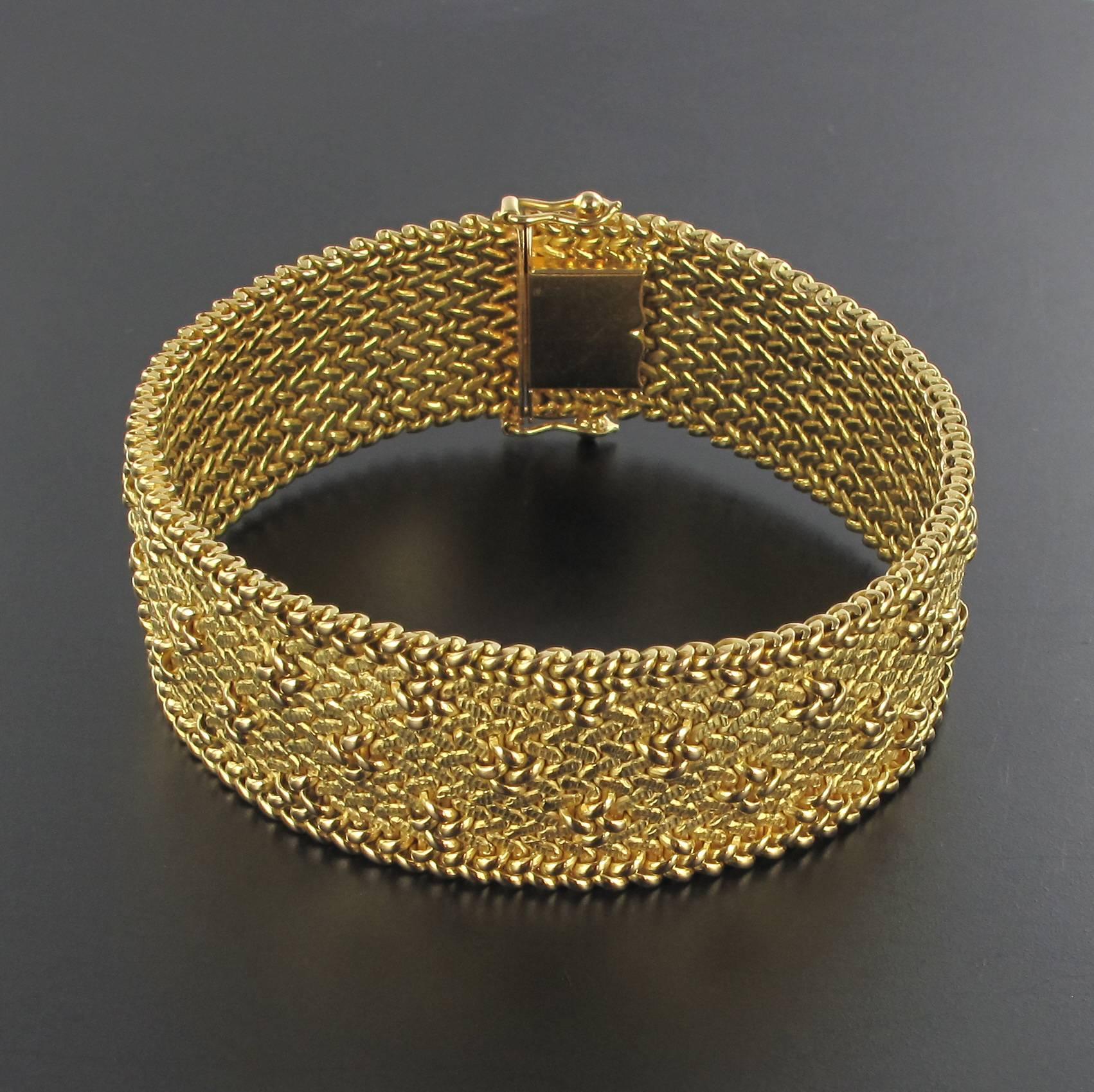 Bracelet in 18 carat yellow gold, eagle head hallmark.
This antique golden bracelet is composed of a flexible woven milanese mesh with small gold motifs on the top and edged with a braid of gold. The clasp is in the form of a clip with 2 safety 8