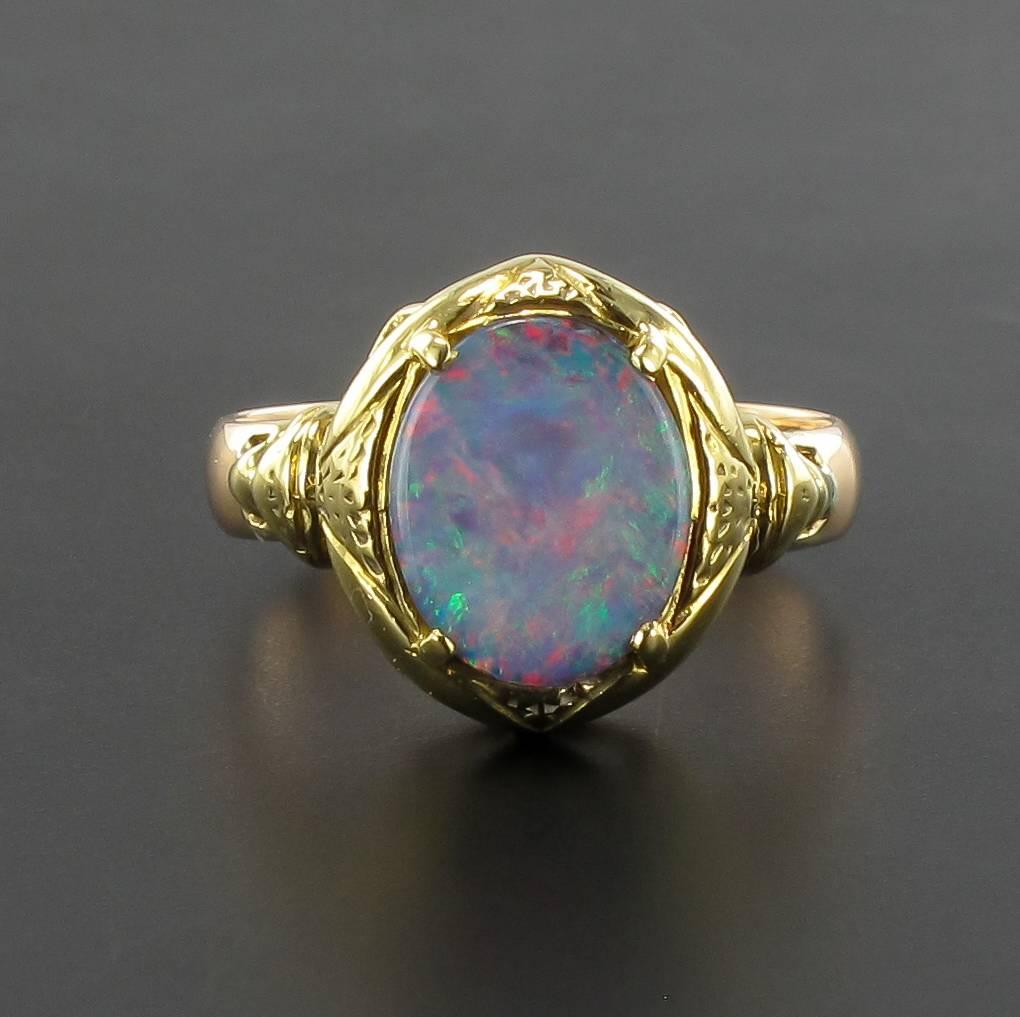 Ring in 18 carat yellow gold.

A superb original antique ring claw set with an opal doublet cabochon. It features a chiselled mount that leads into the ring band. 

Total weight of the opal: 1.60 carat approximately.
Length: 14,3 mm, Width: 13,2 mm,