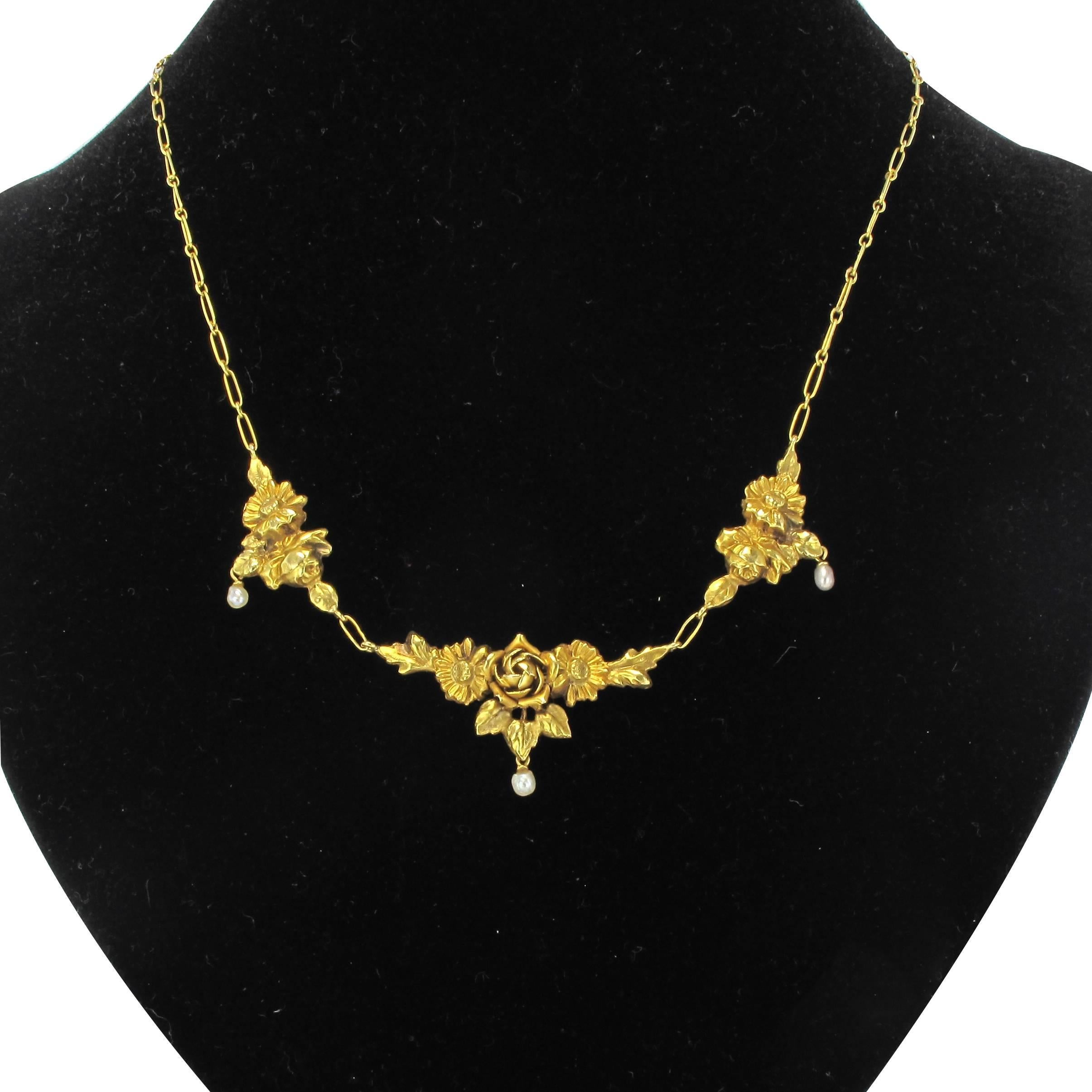 Necklace in yellow gold, 18 carats, 750 thousandths, eagle's head hallmark.
This stunning antique yellow gold necklace is composed of 3 motifs representing roses and leaves each holding a suspended natural baroque pearl. The motifs are held and