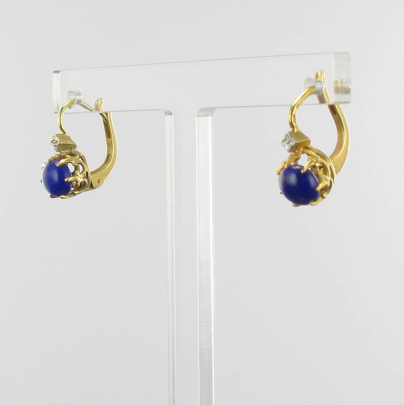 Earrings in 18 carat yellow gold, horse head hallmark. 

These stunning yellow gold sleeper earrings are set with lapis lazuli cabochons held by fleur-de-lis claws with small white gold motifs above. 

Diameter of lapis lazuli: 5.7 mm.
Overall
