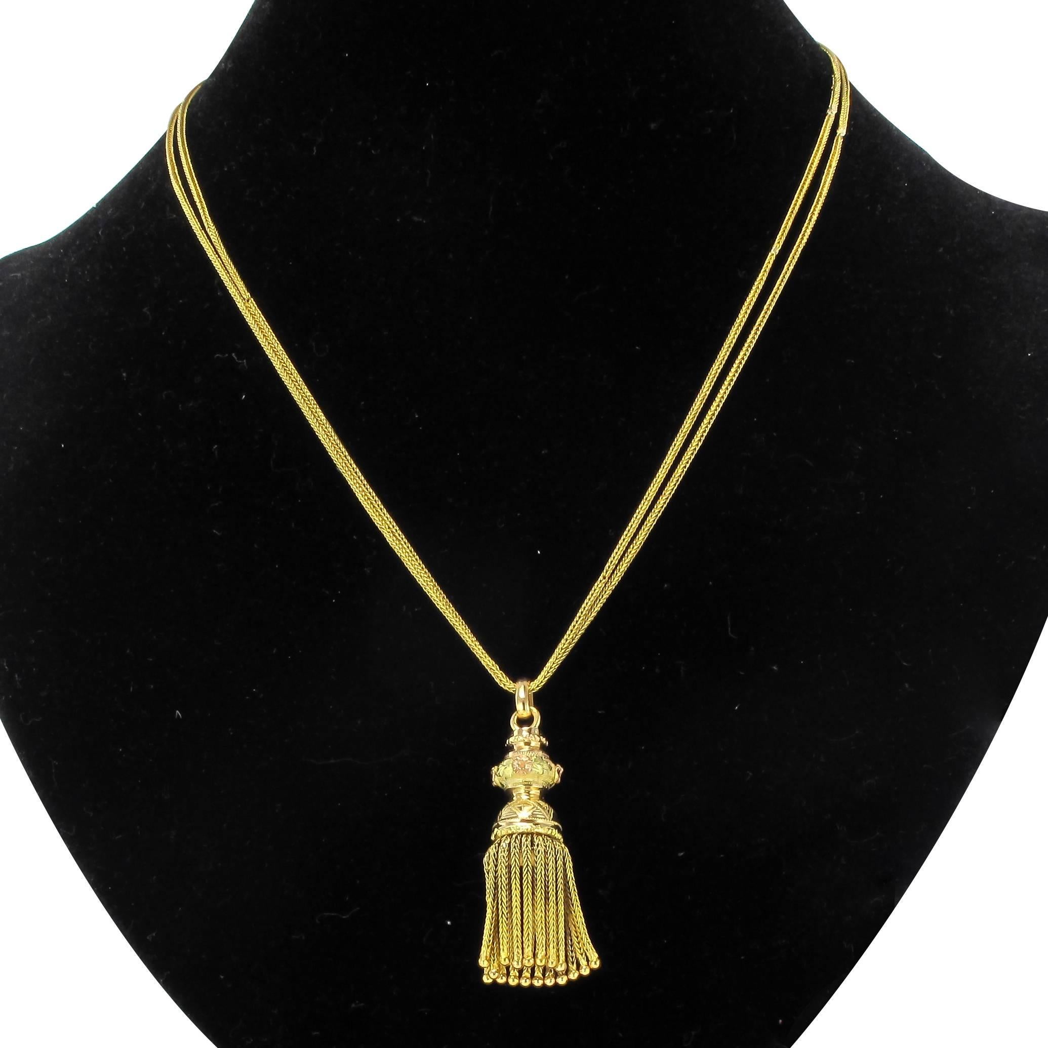 Necklace in 18 carat yellow gold, eagle head hallmark. 

This antique necklace is composed of a double wheat ear link chain from which is suspended a gold pompom with a finely chiselled corolla decorated with small motifs in green and rose gold. It