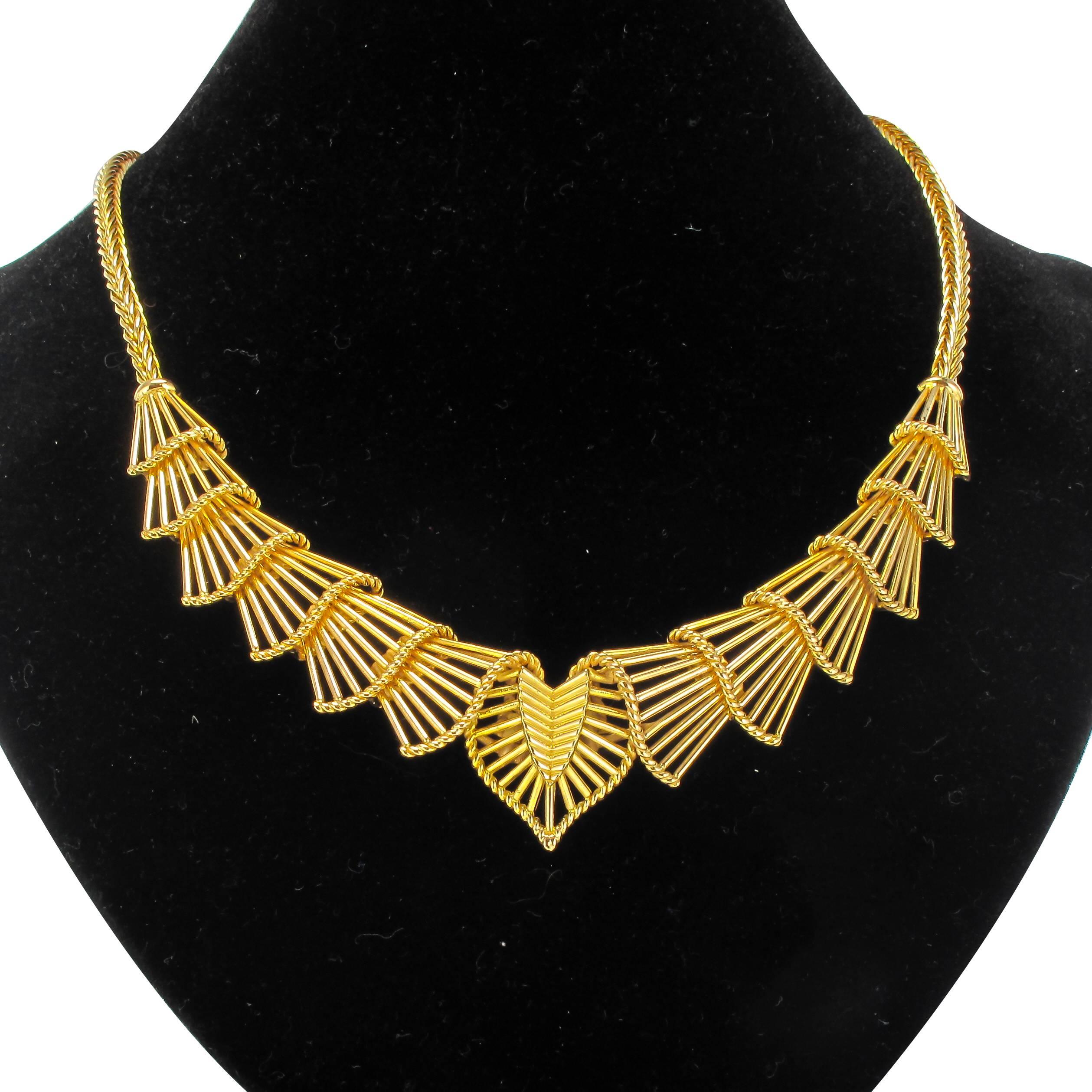 18 carat yellow gold necklace, 750 thousandths, rhinoceros head hallmark. 
This superb gold necklace features a design formed of curved openwork gold fan shapes edged with gold braid. This series of motifs is connected at each end to a palm link