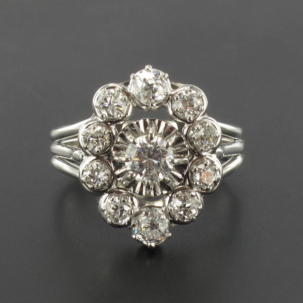 Ring in platinium, dog's head hallmark and 18 carat white gold, eagle head hallmark. 

This splendid antique diamond ring features a central claw set modern brilliant cut diamond which is edged by a strand of white gold with 8 brilliant cut