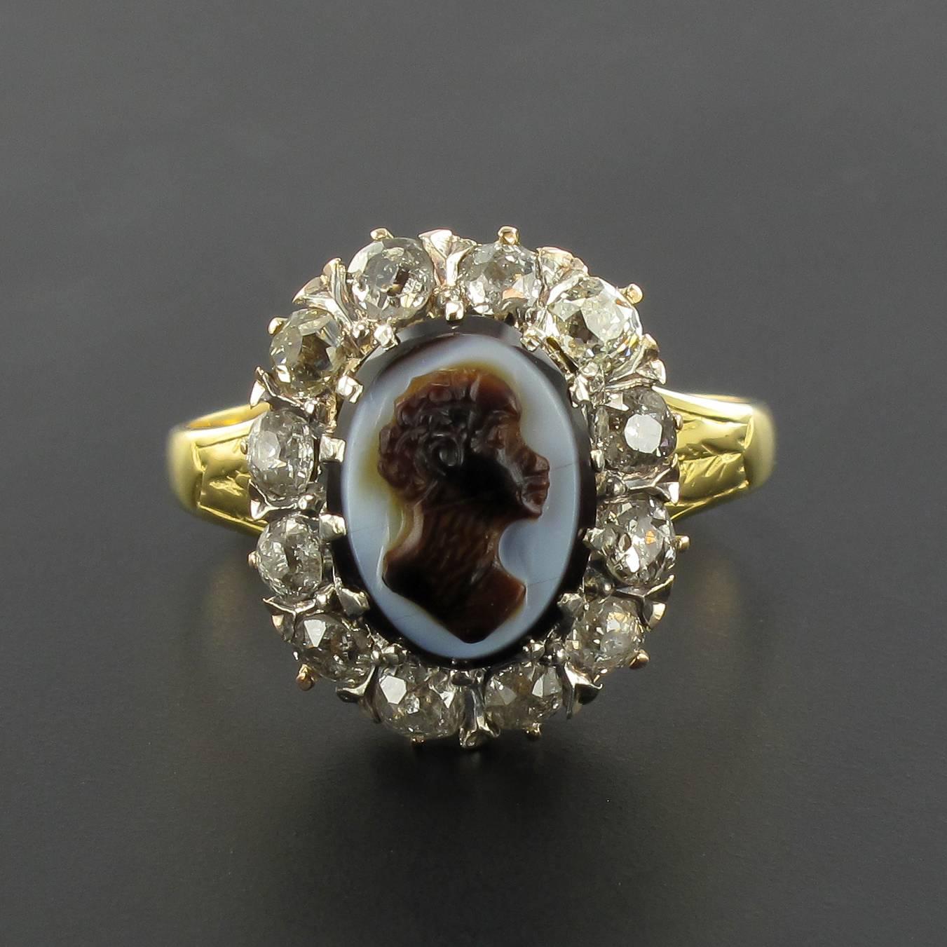 18 carat yellow gold ring, eagle head hallmark. 

This rare and splendid antique ring is claw set with a cameo on agate representing a man’s profile. The cameo is surrounded by 12 antique cut diamonds in an openwork mount. 
The beginning of the ring