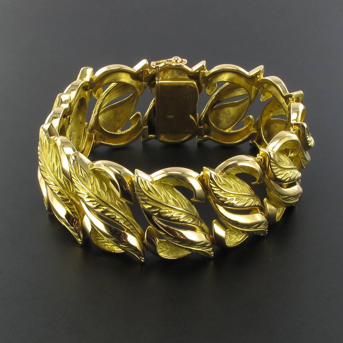 18 karat yellow gold bracelet, rhino and eagle heads hallmarks. 
This wide articulated bracelet is composed of engraved motifs representing leaves that intertwine. Each motif is joined to each other by hinges that assist with the articulation. It