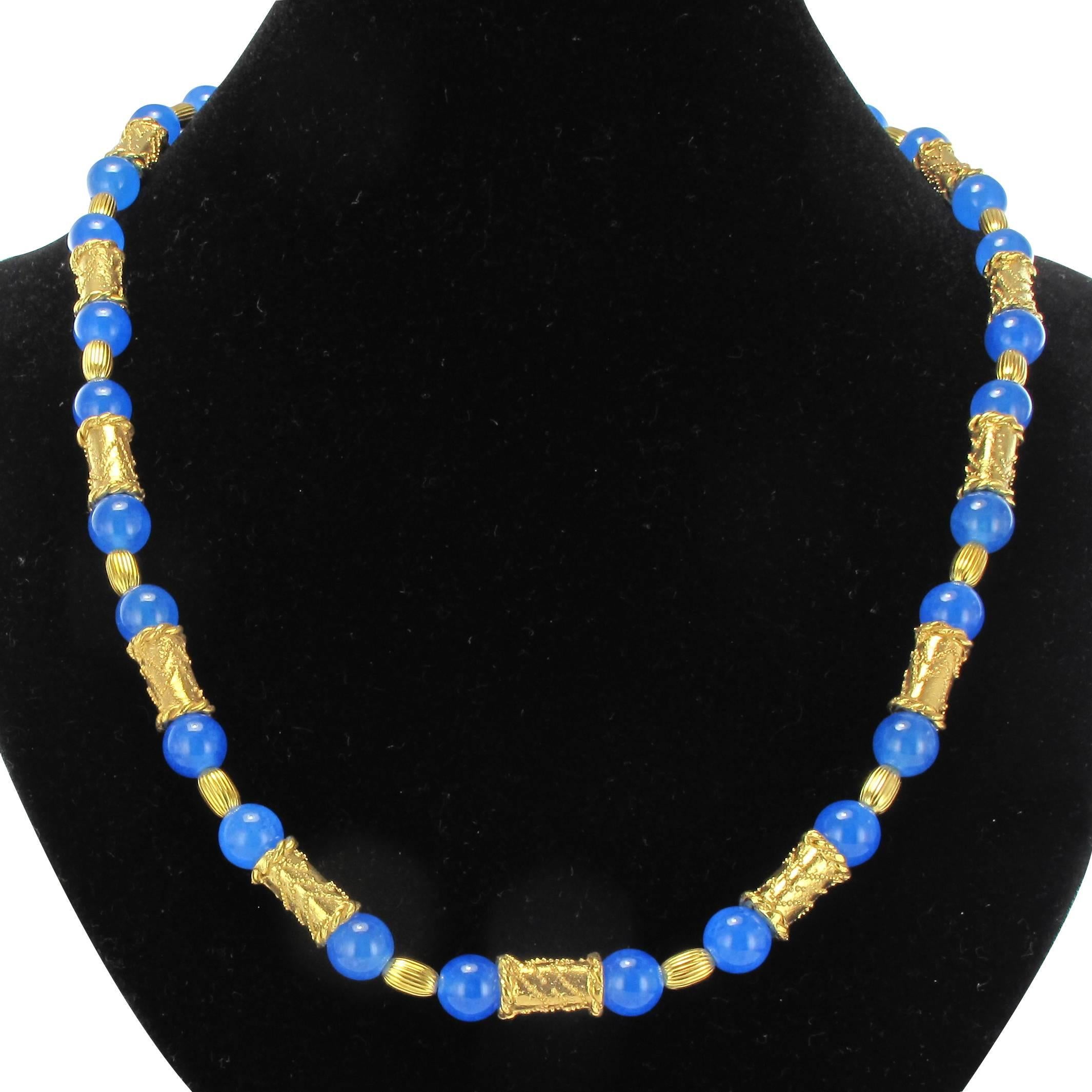 Necklace in vermeil, silver and yellow gold.

It is made of blue glass beads separated by gilt silver motifs carved in the spirit of Etruscan art and of ribbed vermilion beads of olive shape, the necklace ending in a chain allowing to adapt the
