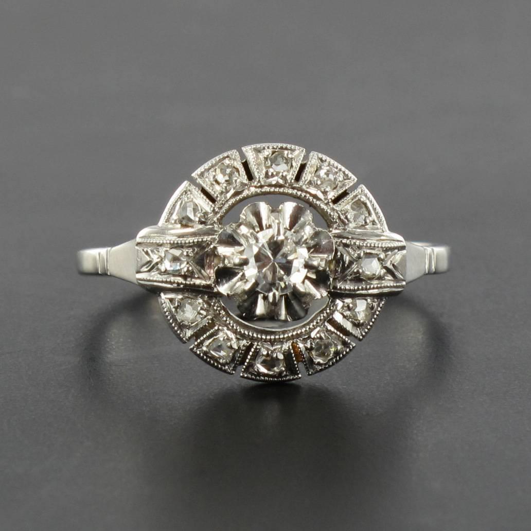 Platinum ring and 18 carats white gold, dog and eagle head hallmarks.

This gorgeous round antique ring is claw set with a brilliant cut diamond surrounded by rose cut diamonds within a geometric design setting. It features a delicate openwork ring