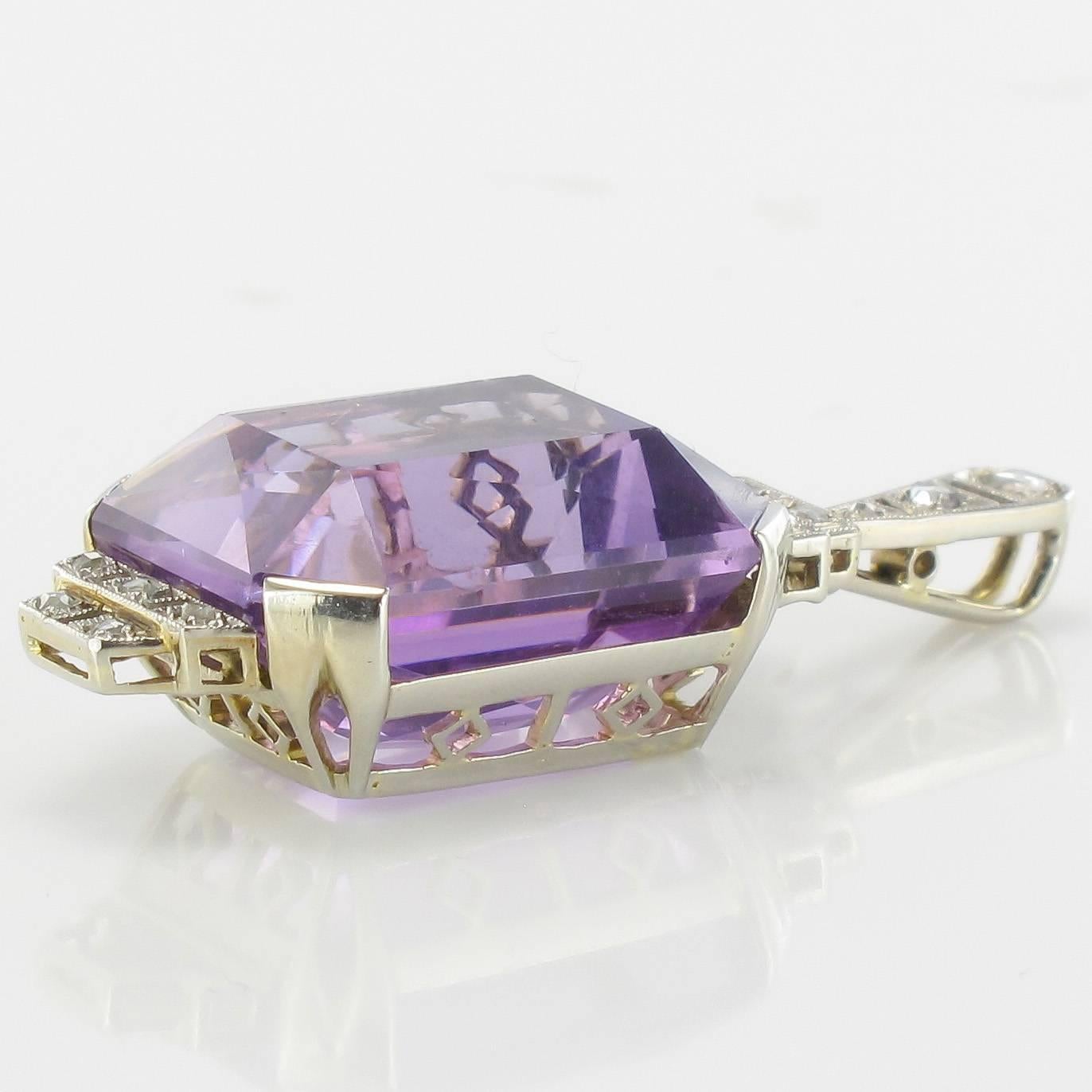 Platinum pendant and 18 carat white gold, dog and eagle head hallmarks.

This magnificent Art Deco pendant necklace has a geometric shaped design claw set with an emerald cut amethyst and rose cut diamonds, including in the bail itself. 
The setting