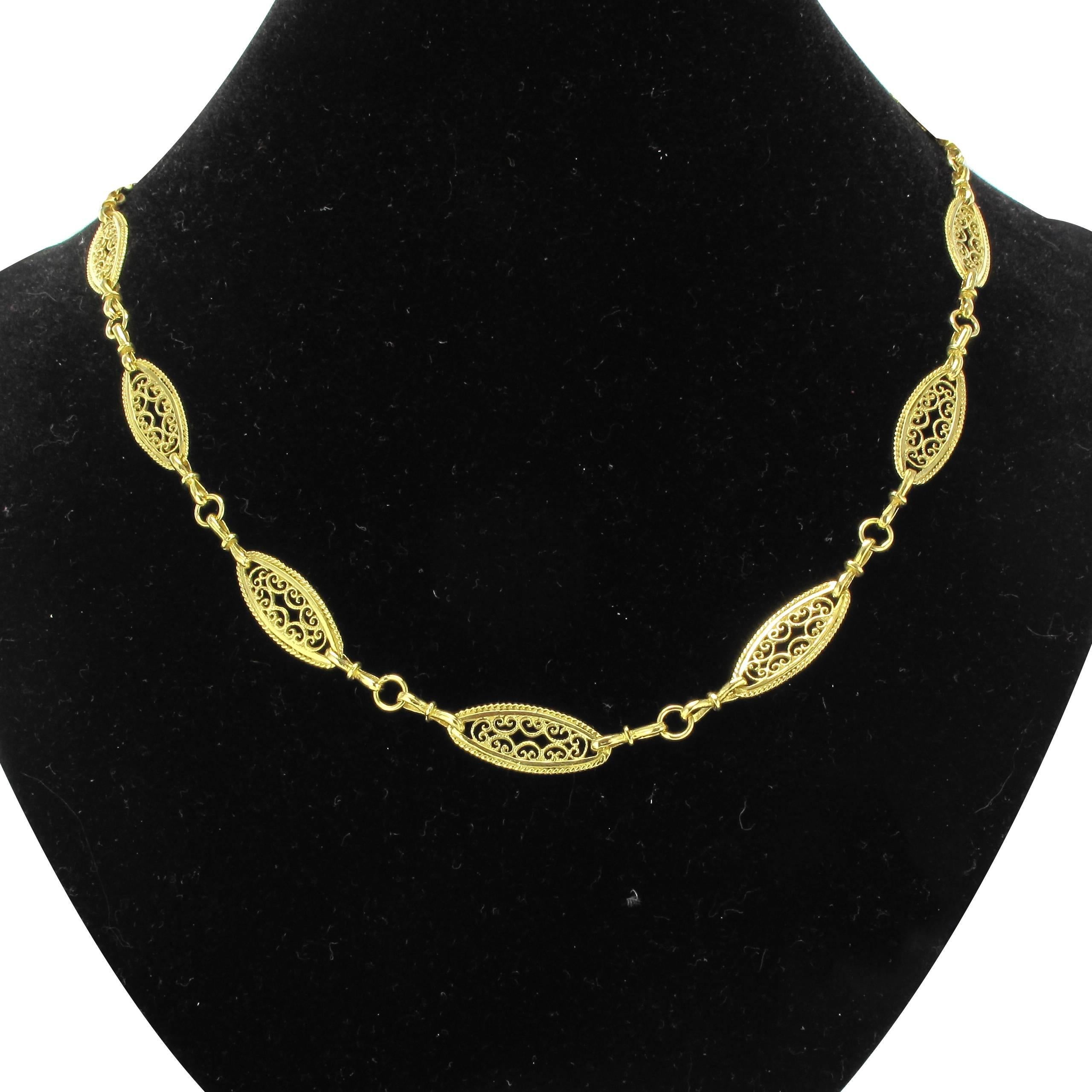 18 carat yellow gold necklace, eagle head hallmark.

This gorgeous antique necklace is composed of openwork shuttle shaped links of a filigree design separated by belcher chain. The clasp is a spring ring. 

Overall length: 59,7 cm, width at the